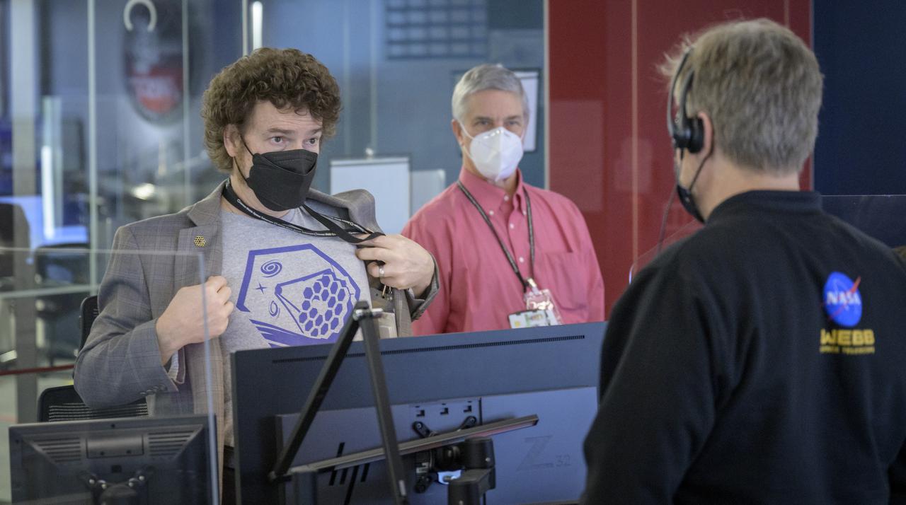 NASA James Webb Space Telescope Mission Operations Manager Carl Starr, left, shows his Webb shirt to NASA James Webb Space Telescope Commissioning Manager John Durning, right, as they prepare to monitor the progress of the observatory’s second primary mirror wing rotating into position, Saturday, Jan. 8, 2022, at NASA’s James Webb Space Telescope Mission Operations Center at the Space Telescope Science Institute in Baltimore. Webb, an infrared telescope with a 21.3-foot (6.5-meter) primary mirror, was folded up for launch and underwent an unprecedented deployment process to unfold in space. As NASA's next flagship observatory, Webb will study every phase of cosmic history—from within our solar system to the most distant observable galaxies in the early universe. Photo Credit: (NASA/Bill Ingalls)