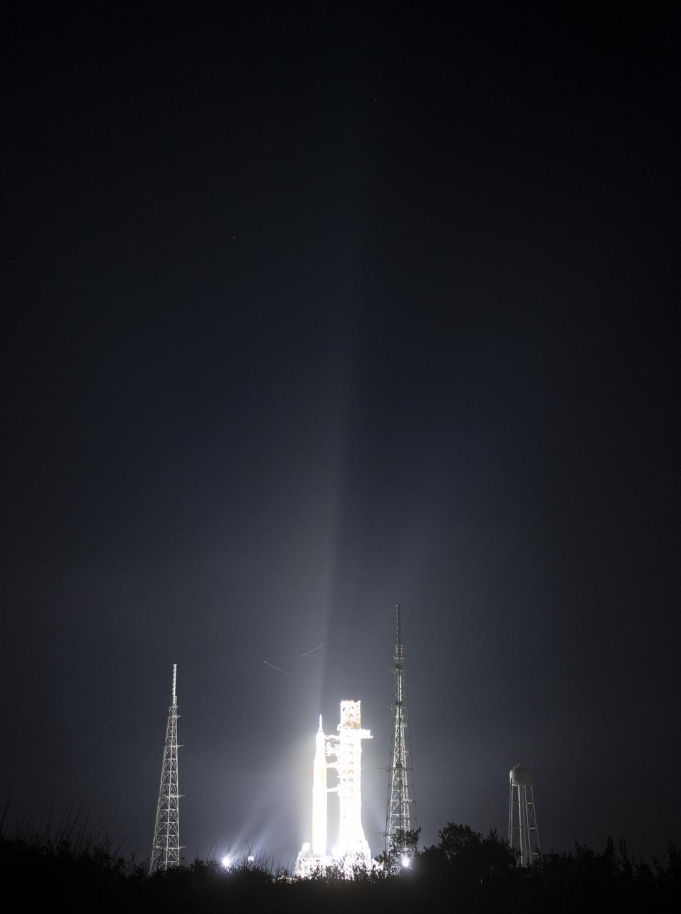 NASA’s Space Launch System (SLS) rocket with the Orion spacecraft aboard is seen illuminated by spotlights atop a mobile launcher at Launch Complex 39B, Friday, March 18, 2022, after being rollout out to the launch pad for the first time at NASA’s Kennedy Space Center in Florida. Ahead of NASA’s Artemis I flight test, the fully stacked and integrated SLS rocket and Orion spacecraft will undergo a wet dress rehearsal at Launch Complex 39B to verify systems and practice countdown procedures for the first launch. Photo Credit: (NASA/Joel Kowsky)