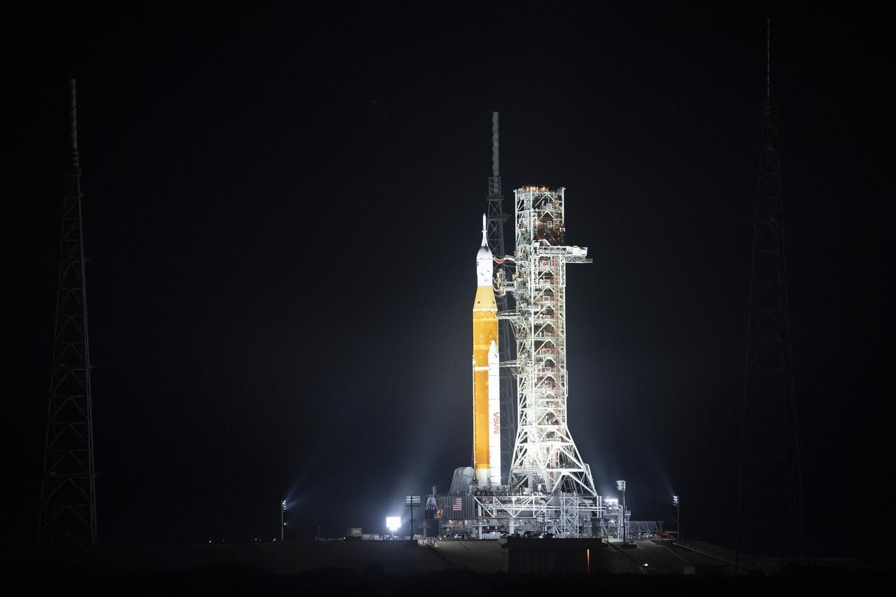 NASA’s Space Launch System (SLS) rocket with the Orion spacecraft aboard is seen illuminated by spotlights atop a mobile launcher at Launch Complex 39B, Friday, March 18, 2022, after being rollout out to the launch pad for the first time at NASA’s Kennedy Space Center in Florida. Ahead of NASA’s Artemis I flight test, the fully stacked and integrated SLS rocket and Orion spacecraft will undergo a wet dress rehearsal at Launch Complex 39B to verify systems and practice countdown procedures for the first launch. Photo Credit: (NASA/Joel Kowsky)