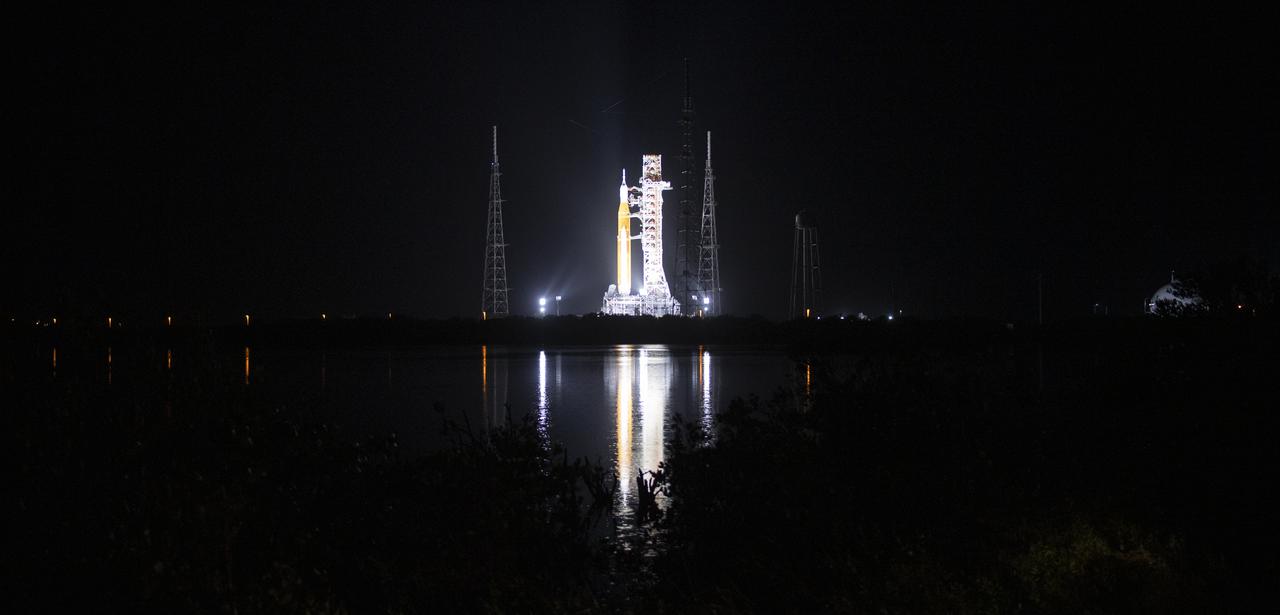 NASA’s Space Launch System (SLS) rocket with the Orion spacecraft aboard is seen atop a mobile launcher at Launch Complex 39B illuminated by spotlights, Saturday, April 2, 2022, as the Artemis I launch team conducts the wet dress rehearsal test at NASA’s Kennedy Space Center in Florida. Ahead of NASA’s Artemis I flight test, the wet dress rehearsal will run the Artemis I launch team through operations to load propellant, conduct a full launch countdown, demonstrate the ability to recycle the countdown clock, and drain the tanks to practice timelines and procedures for launch.  Photo Credit: (NASA/Joel Kowsky)