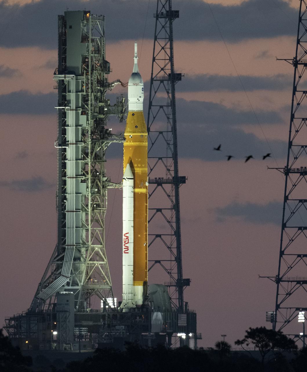 NASA’s Space Launch System (SLS) rocket with the Orion spacecraft aboard is seen at sunrise atop a mobile launcher at Launch Complex 39B, Monday, April 4, 2022, as the Artemis I launch team conducts the wet dress rehearsal test at NASA’s Kennedy Space Center in Florida. Ahead of NASA’s Artemis I flight test, the wet dress rehearsal will run the Artemis I launch team through operations to load propellant, conduct a full launch countdown, demonstrate the ability to recycle the countdown clock, and drain the tanks to practice timelines and procedures for launch.  Photo Credit: (NASA/Joel Kowsky)