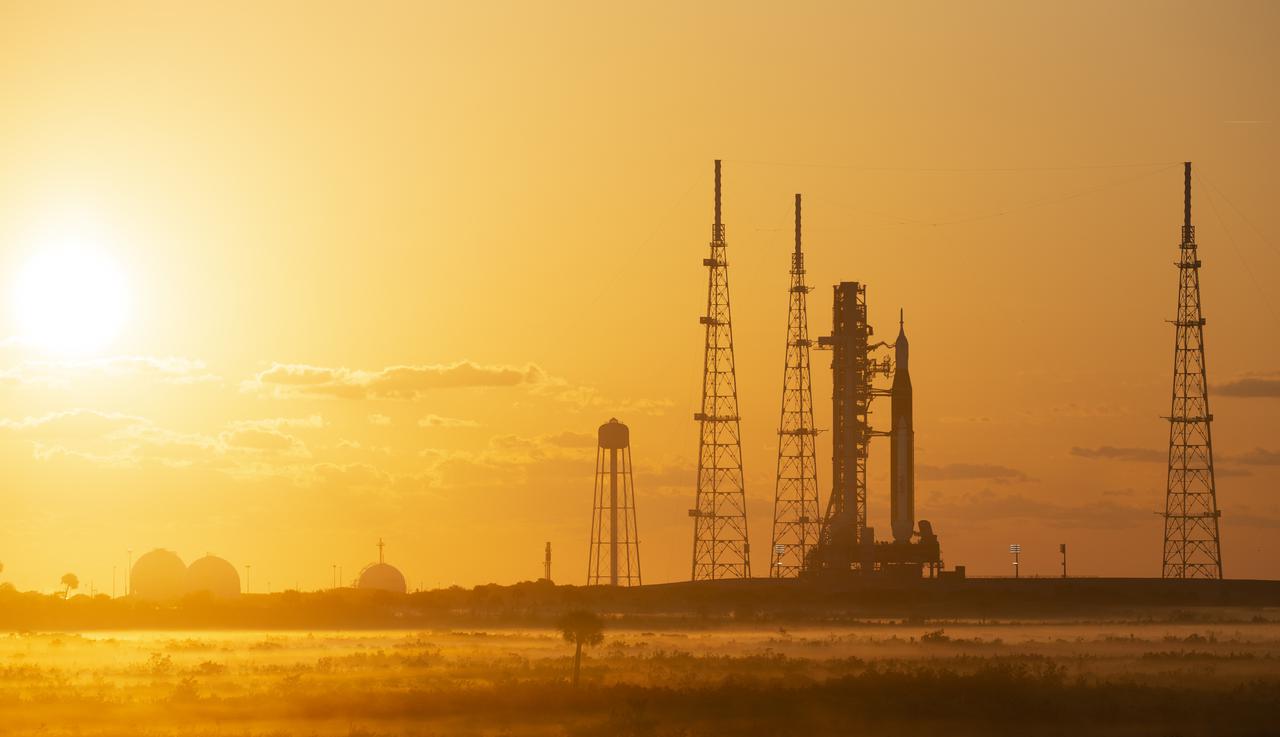 NASA’s Space Launch System (SLS) rocket with the Orion spacecraft aboard is seen at sunrise atop a mobile launcher at Launch Complex 39B, Monday, April 4, 2022, as the Artemis I launch team conducts the wet dress rehearsal test at NASA’s Kennedy Space Center in Florida. Ahead of NASA’s Artemis I flight test, the wet dress rehearsal will run the Artemis I launch team through operations to load propellant, conduct a full launch countdown, demonstrate the ability to recycle the countdown clock, and drain the tanks to practice timelines and procedures for launch.  Photo Credit: (NASA/Joel Kowsky)