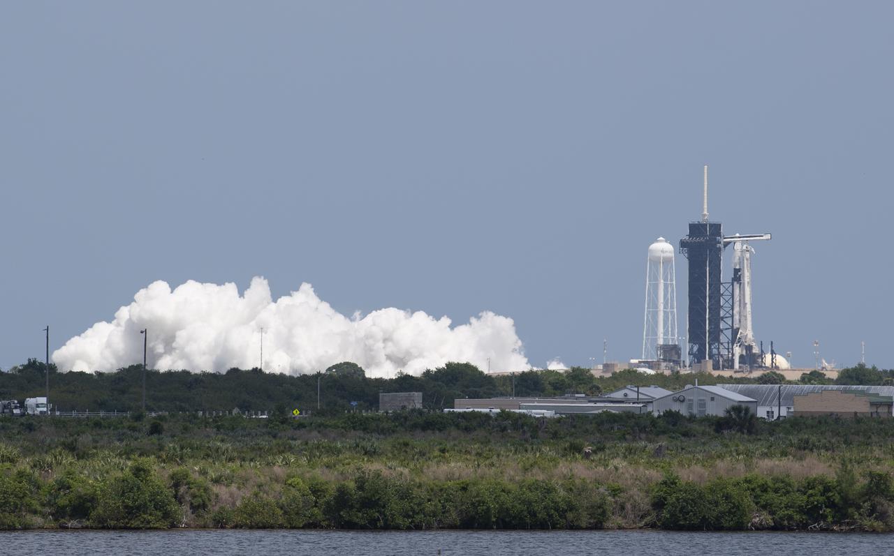 A SpaceX Falcon 9 rocket with the company's Crew Dragon spacecraft aboard is seen on the launch pad at Launch Complex 39A during a brief static fire test ahead of Axiom Mission 1 (Ax-1), Wednesday, April 6, 2022, at NASA’s Kennedy Space Center in Florida. The Ax-1 mission is the first private astronaut mission to the International Space Station.  Ax-1 crew members Commander Michael López-Alegría of Spain and the United States, Pilot Larry Connor of the United States, and Mission Specialists Eytan Stibbe of Israel, and Mark Pathy of Canada are scheduled to launch on no earlier than March 20, from Launch Complex 39A at the Kennedy Space Center. Photo Credit: (NASA/Joel Kowsky)