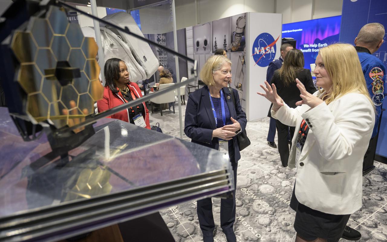 NASA Deputy Administrator Pam Melroy, center, talks with NASA James Webb Space Telescope public affairs officer Laura Betz at the NASA Exhibit area during the 37th Space Symposium, Wednesday, April 6, 2022, in Colorado Springs, Colorado. Photo Credit: (NASA/Bill Ingalls)