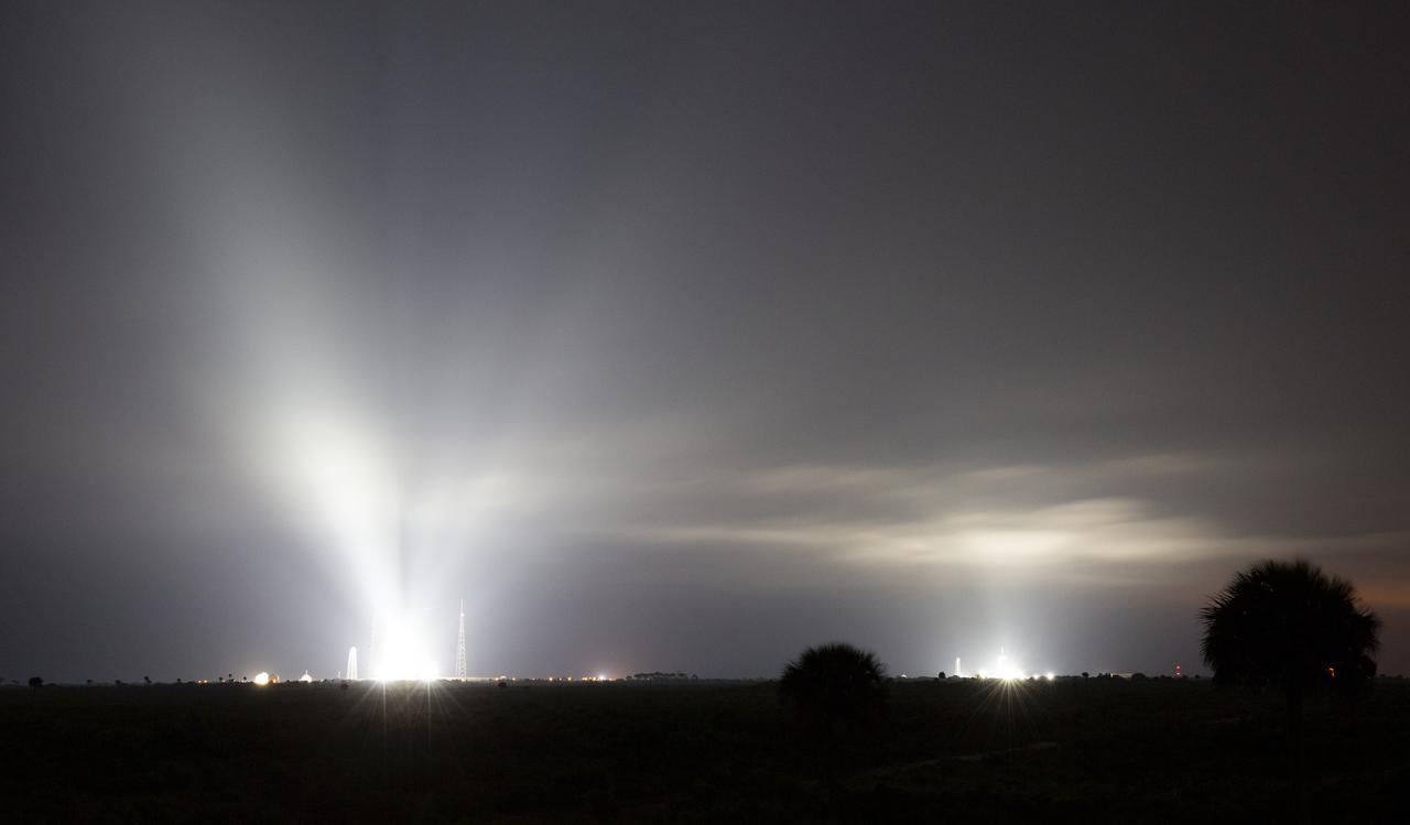 NASA’s Space Launch System (SLS) rocket with the Orion spacecraft aboard atop a mobile launcher at Launch Complex 39B as the Artemis I launch team prepares for the next attempt of the wet dress rehearsal test, left, and a SpaceX Falcon 9 rocket with the company's Crew Dragon spacecraft aboard on the launch pad at Launch Complex 39A as preparations continue for Axiom Mission 1 (Ax-1), are seen illuminated by spotlights, Thursday, April 7, 2022, at NASA’s Kennedy Space Center in Florida. The Ax-1 mission is the first private astronaut mission to the International Space Station.  Ax-1 crew members Commander Michael López-Alegría of Spain and the United States, Pilot Larry Connor of the United States, and Mission Specialists Eytan Stibbe of Israel, and Mark Pathy of Canada launched on April 8 at 11:17 a.m. EDT, from Launch Complex 39A at the Kennedy Space Center. Photo Credit: (NASA/Joel Kowsky)