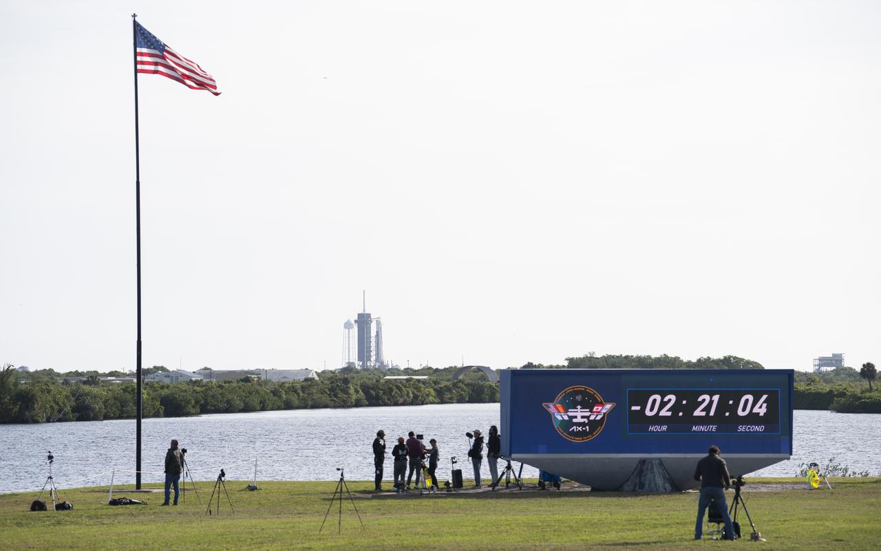 A SpaceX Falcon 9 rocket with the company's Crew Dragon spacecraft aboard is seen on the launch pad at Launch Complex 39A as members of the media are seen next to the countdown clock at NASA’s Kennedy Space Center Press Site ahead of launch of Axiom Mission 1 (Ax-1), Friday, April 8, 2022, in Florida. The Ax-1 mission is the first private astronaut mission to the International Space Station.  Ax-1 crew members Commander Michael López-Alegría of Spain and the United States, Pilot Larry Connor of the United States, and Mission Specialists Eytan Stibbe of Israel, and Mark Pathy of Canada are scheduled to launch at 11:17 a.m. EDT, from Launch Complex 39A at the Kennedy Space Center. Photo Credit: (NASA/Joel Kowsky)