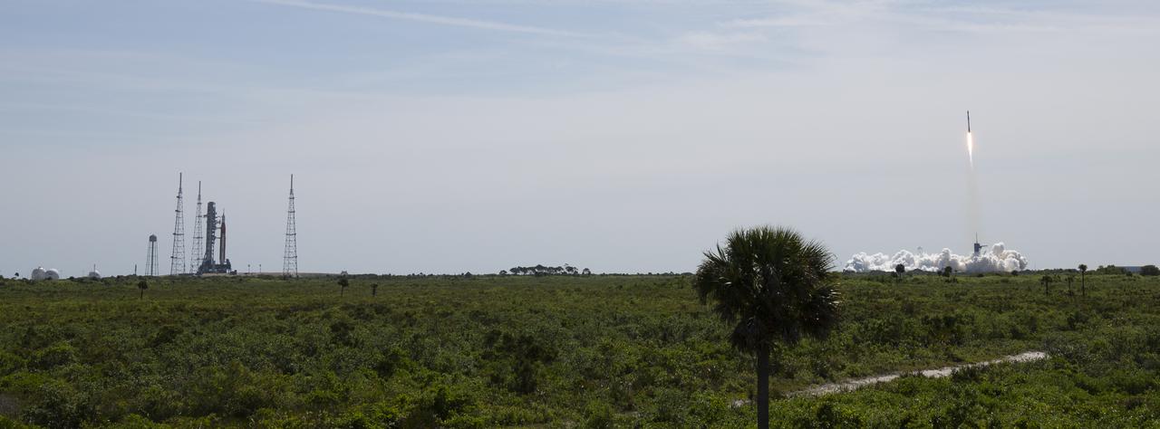NASA’s Space Launch System (SLS) rocket with the Orion spacecraft aboard is seen atop a mobile launcher at Launch Complex 39B, left, as a SpaceX Falcon 9 rocket carrying the company's Crew Dragon spacecraft is launched on Axiom Mission 1 (Ax-1) to the International Space Station with Commander Michael López-Alegría of Spain and the United States, Pilot Larry Connor of the United States, and Mission Specialists Eytan Stibbe of Israel, and Mark Pathy of Canada aboard, Friday, April 8, 2022, at NASA’s Kennedy Space Center in Florida. The Ax-1 mission is the first private astronaut mission to the International Space Station. López-Alegría, Connor, Pathy, Stibbe launched at 11:17 a.m. from Launch Complex 39A at the Kennedy Space Center to begin their 10-day mission. Photo Credit: (NASA/Joel Kowsky)