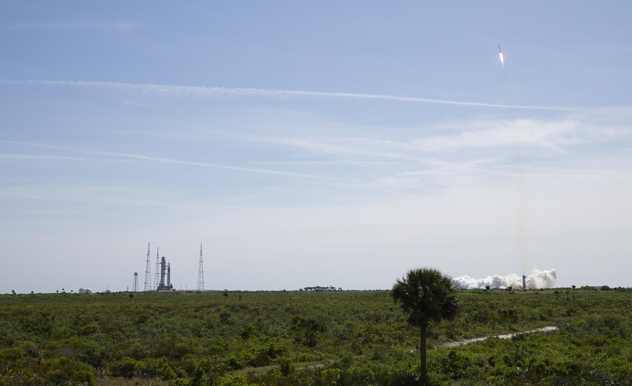 NASA’s Space Launch System (SLS) rocket with the Orion spacecraft aboard is seen atop a mobile launcher at Launch Complex 39B, left, as a SpaceX Falcon 9 rocket carrying the company's Crew Dragon spacecraft is launched on Axiom Mission 1 (Ax-1) to the International Space Station with Commander Michael López-Alegría of Spain and the United States, Pilot Larry Connor of the United States, and Mission Specialists Eytan Stibbe of Israel, and Mark Pathy of Canada aboard, Friday, April 8, 2022, at NASA’s Kennedy Space Center in Florida. The Ax-1 mission is the first private astronaut mission to the International Space Station. López-Alegría, Connor, Pathy, Stibbe launched at 11:17 a.m. from Launch Complex 39A at the Kennedy Space Center to begin their 10-day mission. Photo Credit: (NASA/Joel Kowsky)