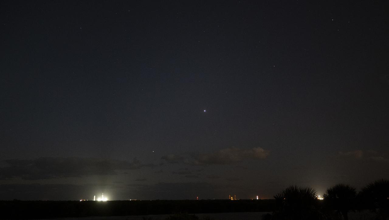 The planets Jupiter, Venus, Mars, and Saturn, from lower left to upper right, are seen above a SpaceX Falcon 9 rocket with the company's Crew Dragon spacecraft onboard illuminated by spotlights on the launch pad at Launch Complex 39A as preparations continue for the Crew-4 mission, Wednesday, April 20, 2022, at NASA’s Kennedy Space Center in Florida. NASA’s SpaceX Crew-4 mission is the fourth crew rotation mission of the SpaceX Crew Dragon spacecraft and Falcon 9 rocket to the International Space Station as part of the agency’s Commercial Crew Program. NASA astronauts Kjell Lindgren, Robert Hines, Jessica Watkins, and ESA (European Space Agency) astronaut Samantha Cristoforetti are scheduled to launch on April 23 at 5:26 a.m. EDT, from Launch Complex 39A at the Kennedy Space Center. Photo Credit: (NASA/Joel Kowsky)