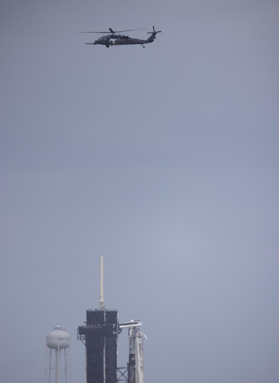 A helicopter is seen flying past a SpaceX Falcon 9 rocket with the company's Crew Dragon spacecraft onboard on the launch pad at Launch Complex 39A as preparations continue for the Crew-4 mission, Thursday, April 21, 2022, at NASA’s Kennedy Space Center in Florida. NASA’s SpaceX Crew-4 mission is the fourth crew rotation mission of the SpaceX Crew Dragon spacecraft and Falcon 9 rocket to the International Space Station as part of the agency’s Commercial Crew Program. NASA astronauts Kjell Lindgren, Robert Hines, Jessica Watkins, and ESA (European Space Agency) astronaut Samantha Cristoforetti are scheduled to launch no earlier than on April 26 from Launch Complex 39A at the Kennedy Space Center. Photo Credit: (NASA/Joel Kowsky)
