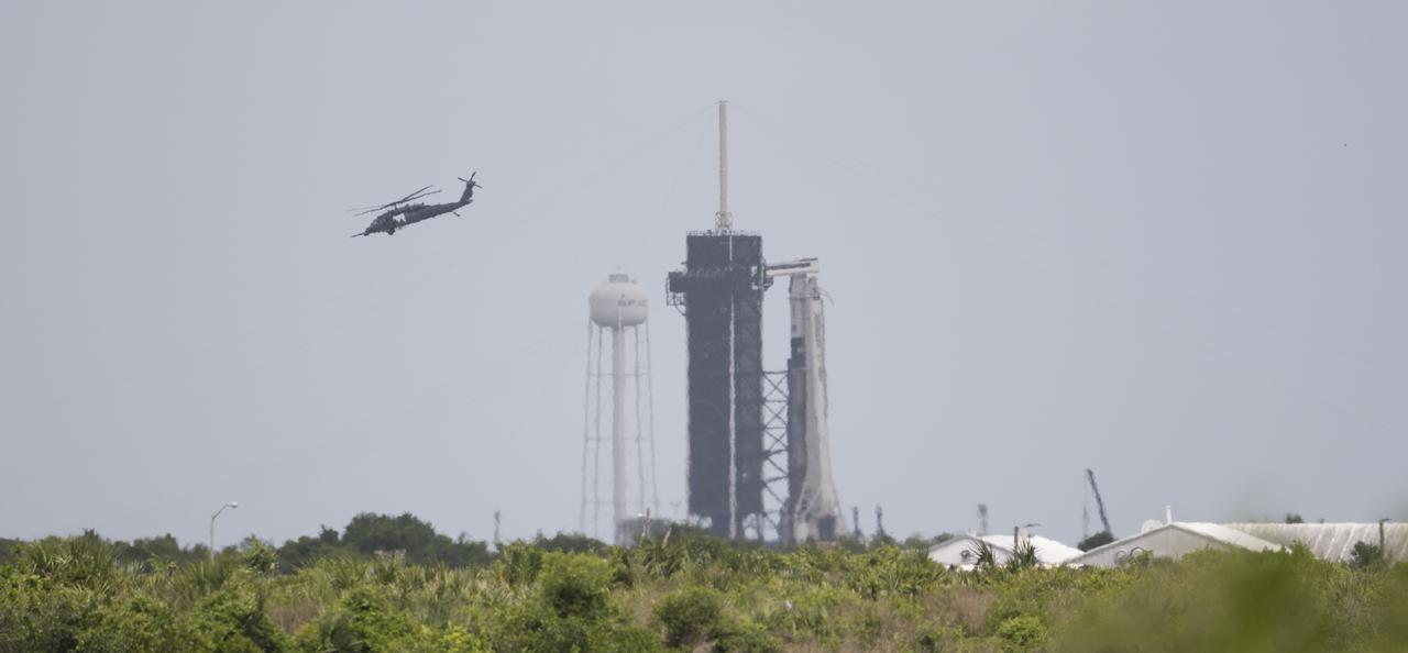 A helicopter is seen flying past a SpaceX Falcon 9 rocket with the company's Crew Dragon spacecraft onboard on the launch pad at Launch Complex 39A as preparations continue for the Crew-4 mission, Thursday, April 21, 2022, at NASA’s Kennedy Space Center in Florida. NASA’s SpaceX Crew-4 mission is the fourth crew rotation mission of the SpaceX Crew Dragon spacecraft and Falcon 9 rocket to the International Space Station as part of the agency’s Commercial Crew Program. NASA astronauts Kjell Lindgren, Robert Hines, Jessica Watkins, and ESA (European Space Agency) astronaut Samantha Cristoforetti are scheduled to launch no earlier than on April 26 from Launch Complex 39A at the Kennedy Space Center. Photo Credit: (NASA/Joel Kowsky)