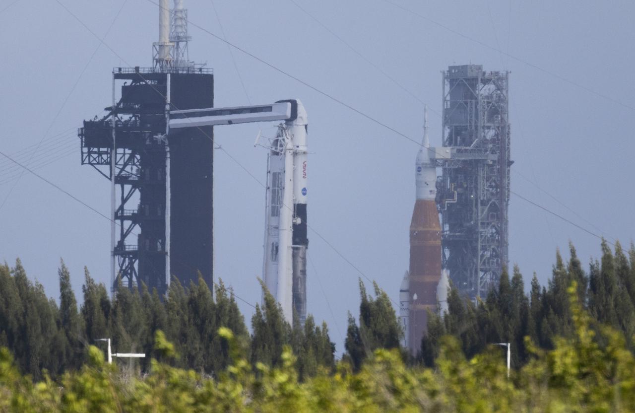 NASA’s Space Launch System (SLS) rocket with the Orion spacecraft aboard is seen atop a mobile launcher at Launch Complex 39B, right, as a SpaceX Falcon 9 rocket with the company's Crew Dragon spacecraft onboard is seen on the launch pad at Launch Complex 39A as preparations continue for the Crew-4 mission, Friday, April 22, 2022, at NASA’s Kennedy Space Center in Florida. NASA’s SpaceX Crew-4 mission is the fourth crew rotation mission of the SpaceX Crew Dragon spacecraft and Falcon 9 rocket to the International Space Station as part of the agency’s Commercial Crew Program. NASA astronauts Kjell Lindgren, Robert Hines, Jessica Watkins, and ESA (European Space Agency) astronaut Samantha Cristoforetti are scheduled to launch no earlier than April 26, from Launch Complex 39A at the Kennedy Space Center. Photo Credit: (NASA/Joel Kowsky)