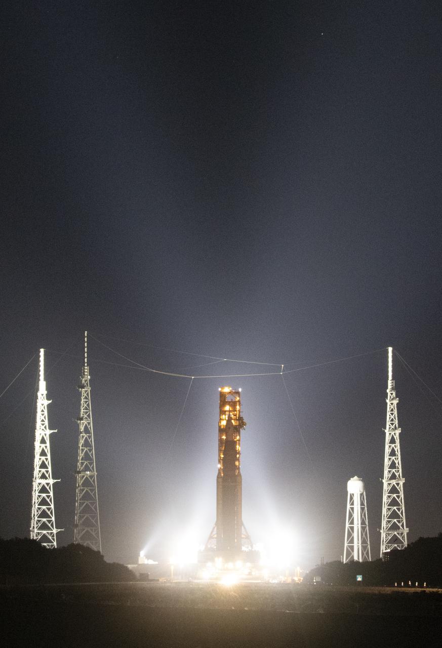 NASA’s Space Launch System (SLS) rocket with the Orion spacecraft aboard is seen atop a mobile launcher as it rolls back to the Vehicle Assembly Building, Monday, April 25, 2022, at NASA’s Kennedy Space Center in Florida. Once inside the Vehicle Assembly Building, teams will work on replacing a faulty upper stage check valve and a small leak within the tail service mast umbilical ground plate housing on the mobile launcher while the supplier for the gaseous nitrogen makes upgrades to their pipeline configuration to support Artemis I testing and launch. Following completion, teams will return to the launch pad to complete the next wet dress rehearsal attempt. Photo Credit: (NASA/Joel Kowsky)
