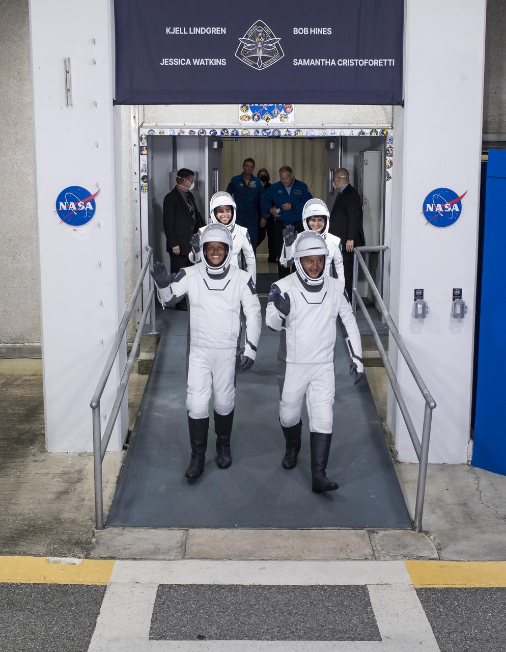 NASA astronauts Robert Hines, left, Kjell Lindgren, right, Jessica Watkins, back left, and ESA (European Space Agency) astronaut Samantha Cristoforetti, wearing SpaceX spacesuits, are seen as they prepare to depart the Neil  A. Armstrong Operations and Checkout Building for Launch Complex 39A to board the SpaceX Crew Dragon spacecraft for the Crew-4 mission launch, Wednesday, April 27, 2022, at NASA’s Kennedy Space Center in Florida. NASA’s SpaceX Crew-4 mission is the fourth crew rotation mission of the SpaceX Crew Dragon spacecraft and Falcon 9 rocket to the International Space Station as part of the agency’s Commercial Crew Program. Lindgren, Hines, Watkins, and Cristoforetti are scheduled to launch at 3:52 a.m. ET on April 27, from Launch Complex 39A at the Kennedy Space Center.  Photo Credit: (NASA/Aubrey Gemignani)
