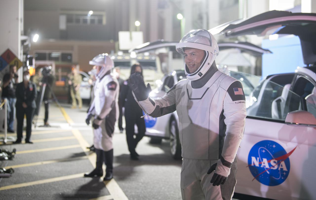 NASA astronaut Kjell Lindgren waves to family and friends as he and crew mates, NASA astronauts Robert Hines, Jessica Watkins, and ESA (European Space Agency) astronaut Samantha Cristoforetti, wearing SpaceX spacesuits, depart the Neil  A. Armstrong Operations and Checkout Building for Launch Complex 39A to board the SpaceX Crew Dragon spacecraft for the Crew-4 mission launch, Tuesday, April 26, 2022, at NASA’s Kennedy Space Center in Florida. NASA’s SpaceX Crew-4 mission is the fourth crew rotation mission of the SpaceX Crew Dragon spacecraft and Falcon 9 rocket to the International Space Station as part of the agency’s Commercial Crew Program. Lindgren, Hines, Watkins, and Cristoforetti are scheduled to launch at 3:52 a.m. ET on April 27, from Launch Complex 39A at the Kennedy Space Center.  Photo Credit: (NASA/Aubrey Gemignani)