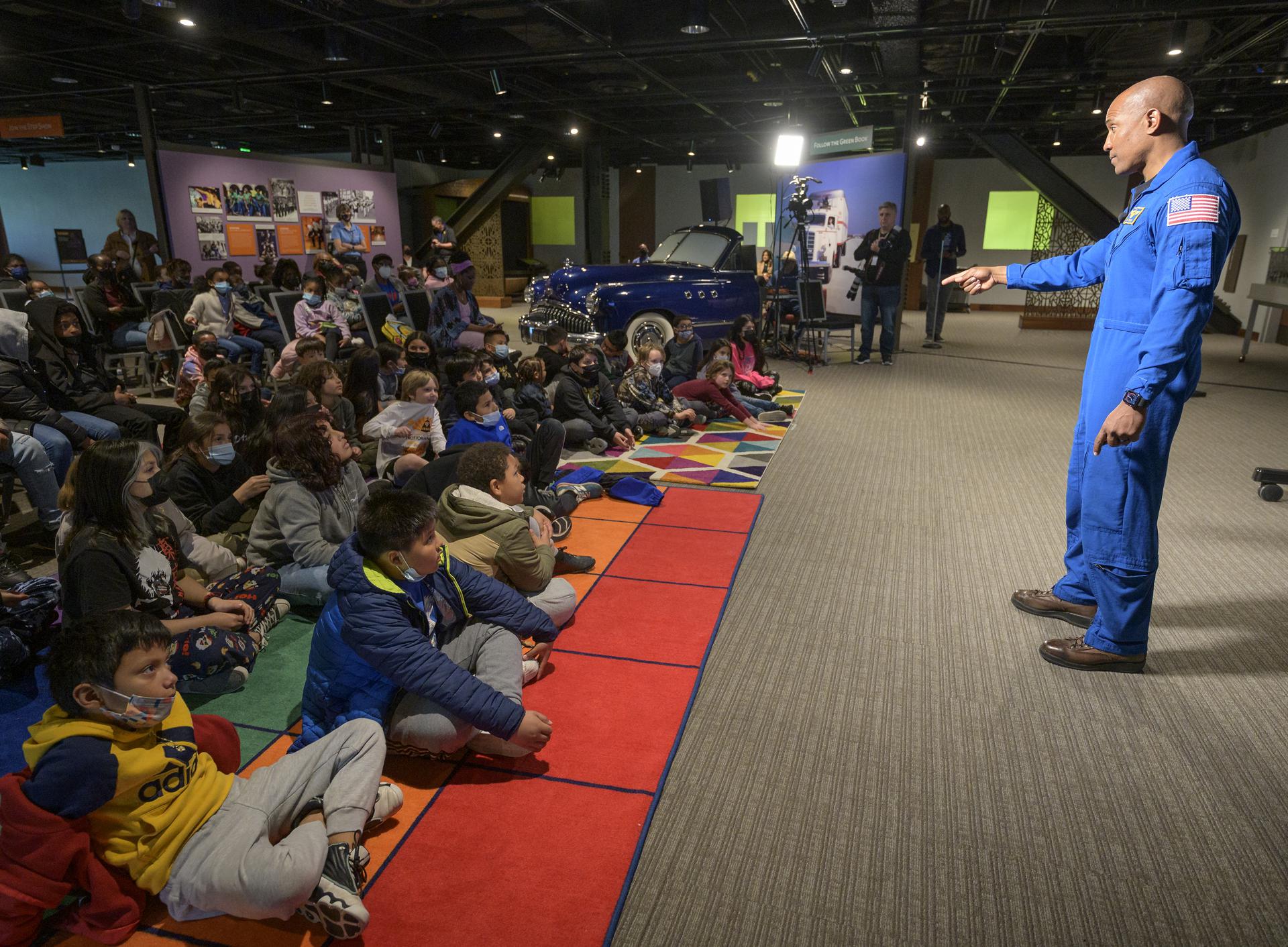 Astronaut Victor Glover speaks to a large group of students