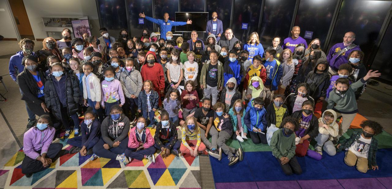 NASA astronaut Victor Glover, back with arms extended, poses for a group photo with school students from Bunker Hill Elementary, Bancroft Elementary, and E.W. Stokes Public Charter School at the conclusion of an educational event, Thursday, April 28, 2022, at the National Museum of African American History and Culture in Washington. Glover most recently served as pilot and second-in-command on the Crew-1 SpaceX Crew Dragon, named Resilience, which landed after a long duration mission aboard the International Space Station, May 2, 2021. Photo Credit: (NASA/Bill Ingalls)