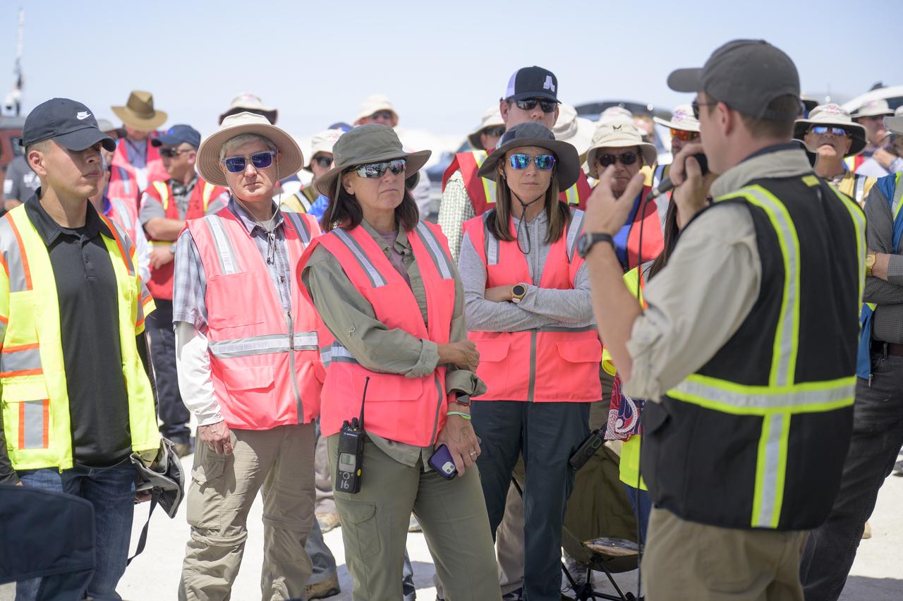 NASA astronaut and Crew Recovery Chief Shannon Walker, center, and other NASA and Boeing teams listen to Boeing Starliner Launch Conductor Louis Atchison as they prepare for the landing of Boeing’s CST-100 Starliner spacecraft at White Sands Missile Range’s Space Harbor, Wednesday, May 25, 2022, in New Mexico. Boeing’s Orbital Flight Test-2 (OFT-2) is Starliner’s second uncrewed flight test to the International Space Station as part of NASA's Commercial Crew Program. OFT-2 serves as an end-to-end test of the system's capabilities. Photo Credit: (NASA/Bill Ingalls)