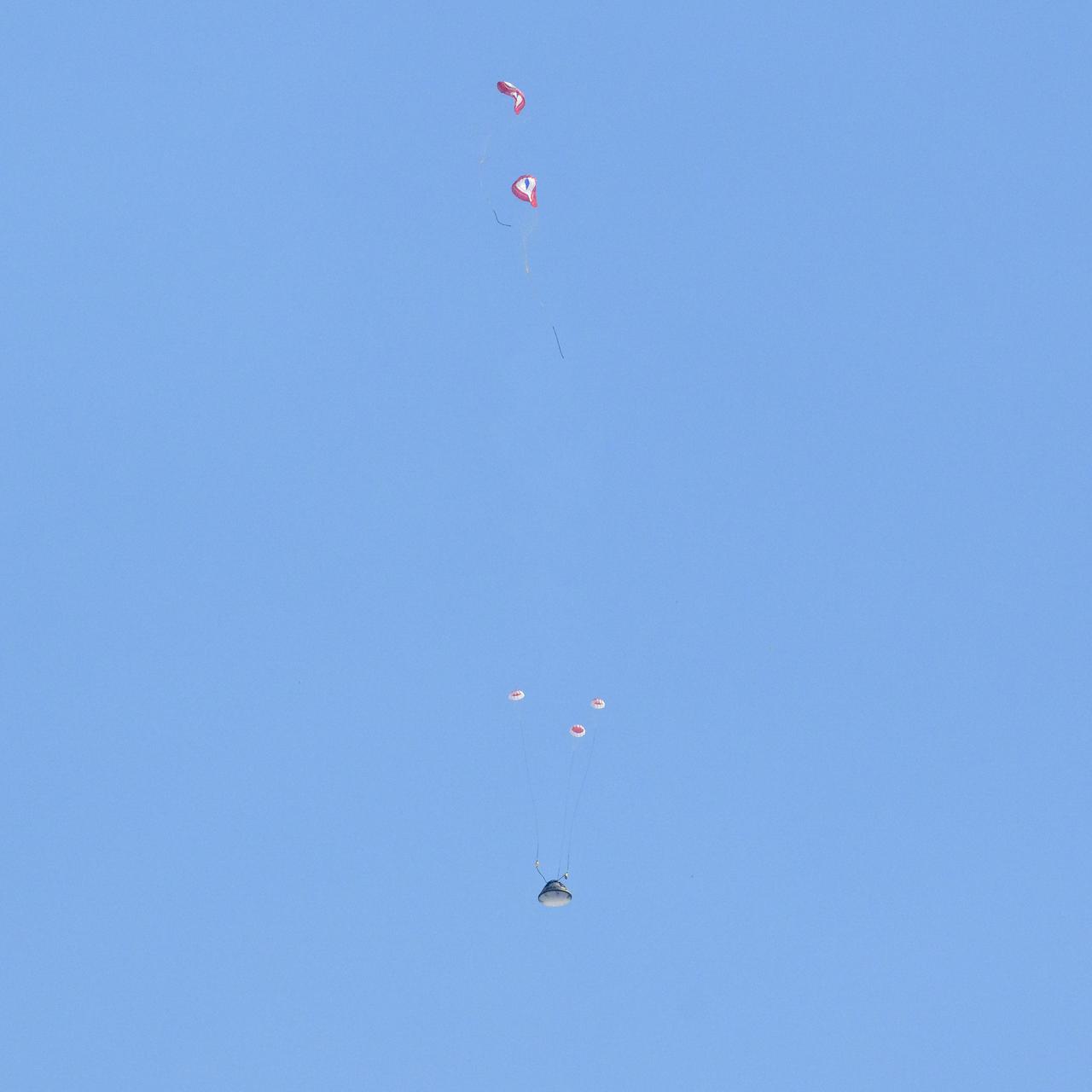 Boeing’s CST-100 Starliner spacecraft transitions to main chutes from drogue parachutes as it lands at White Sands Missile Range’s Space Harbor, Wednesday, May 25, 2022, in New Mexico. Boeing’s Orbital Flight Test-2 (OFT-2) is Starliner’s second uncrewed flight test to the International Space Station as part of NASA's Commercial Crew Program. OFT-2 serves as an end-to-end test of the system's capabilities. Photo Credit: (NASA/Bill Ingalls)