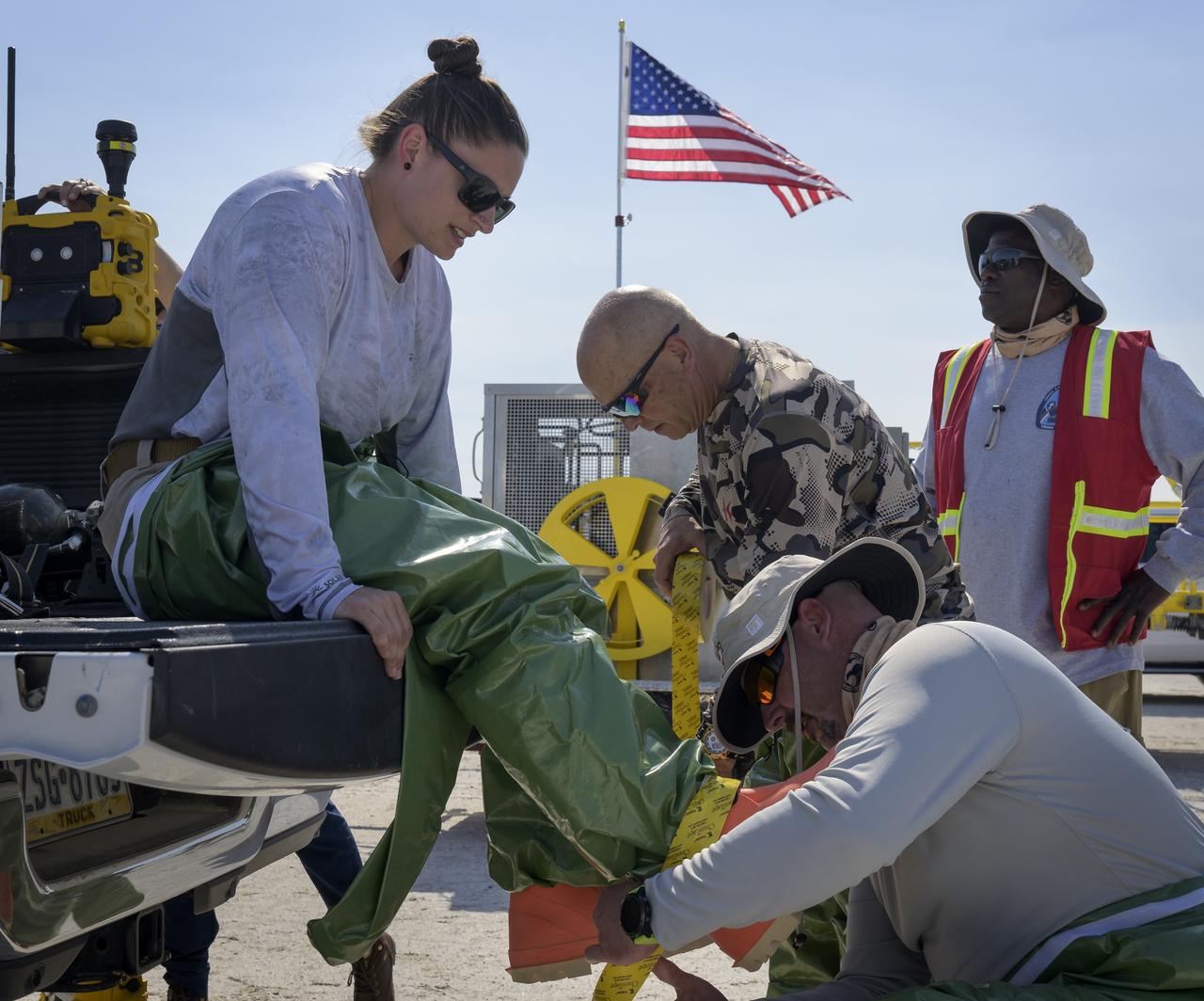 Boeing team members don hazmat suits as they prepare for the landing of Boeing’s CST-100 Starliner spacecraft at White Sands Missile Range’s Space Harbor, Wednesday, May 25, 2022, in New Mexico. Boeing’s Orbital Flight Test-2 (OFT-2) is Starliner’s second uncrewed flight test to the International Space Station as part of NASA's Commercial Crew Program. OFT-2 serves as an end-to-end test of the system's capabilities. Photo Credit: (NASA/Bill Ingalls)