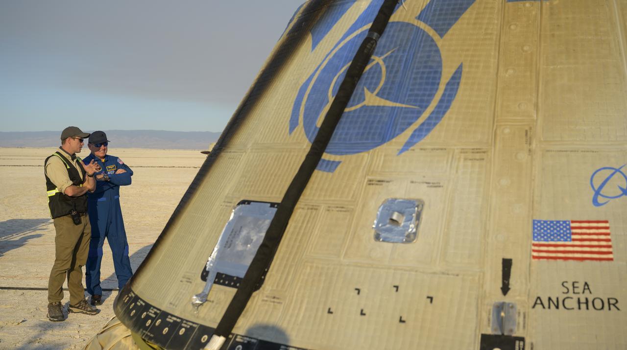 Boeing Starliner Launch Conductor Louis Atchison, left, and NASA astronaut Butch Wilmore look at Boeing’s CST-100 Starliner spacecraft after it landed at White Sands Missile Range’s Space Harbor, Wednesday, May 25, 2022, in New Mexico. Boeing’s Orbital Flight Test-2 (OFT-2) is Starliner’s second uncrewed flight test to the International Space Station as part of NASA's Commercial Crew Program. OFT-2 serves as an end-to-end test of the system's capabilities. Photo Credit: (NASA/Bill Ingalls)