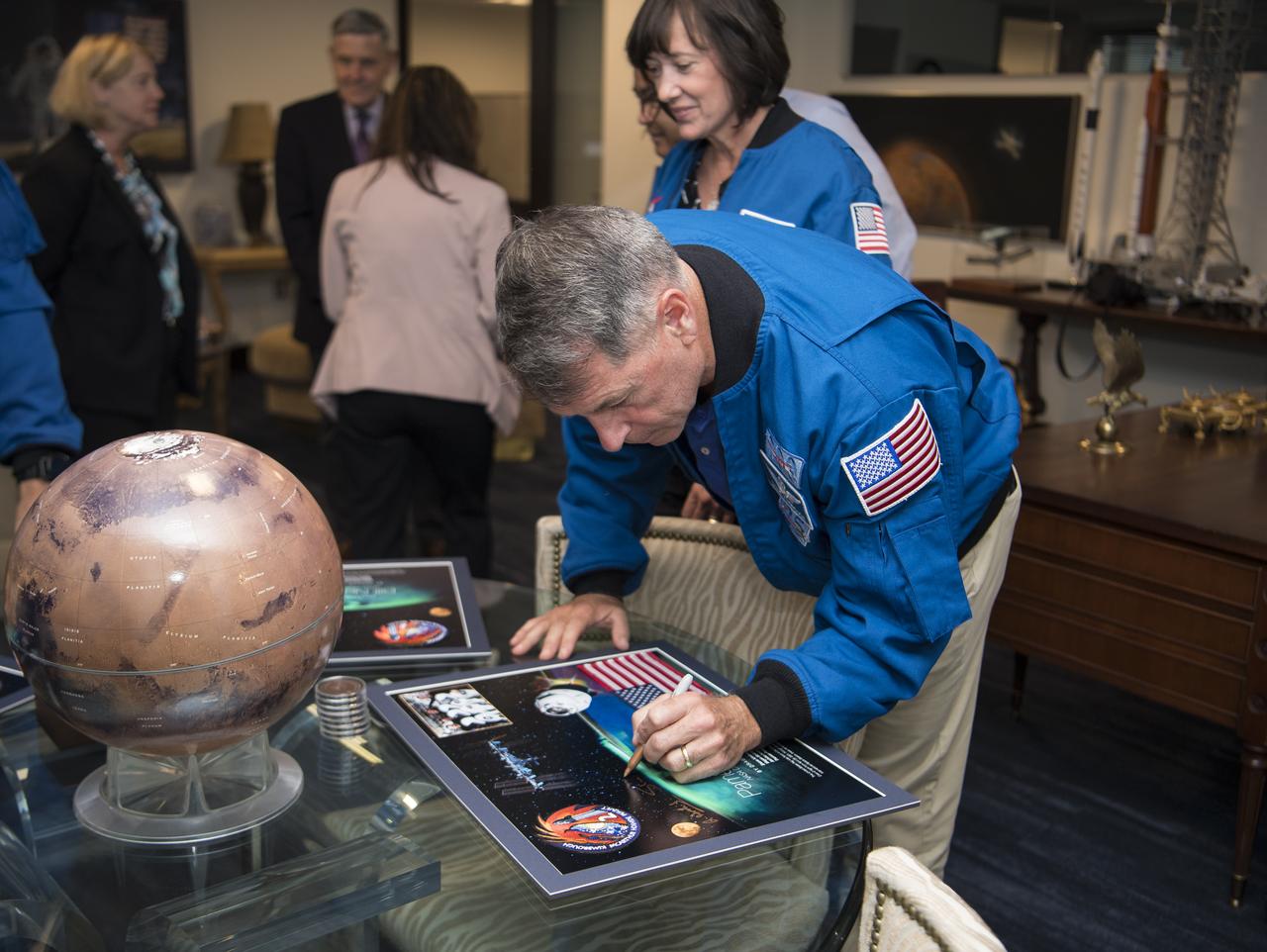 NASA’s SpaceX Crew-2 astronaut Shane Kimbrough signs a montage for NASA Deputy Administrator Pam Melroy while fellow Crew-2 members look on, Monday, June 6, 2022, at the Mary W. Jackson NASA Headquarters Building in Washington DC. Photo Credit: (NASA/Aubrey Gemignani)