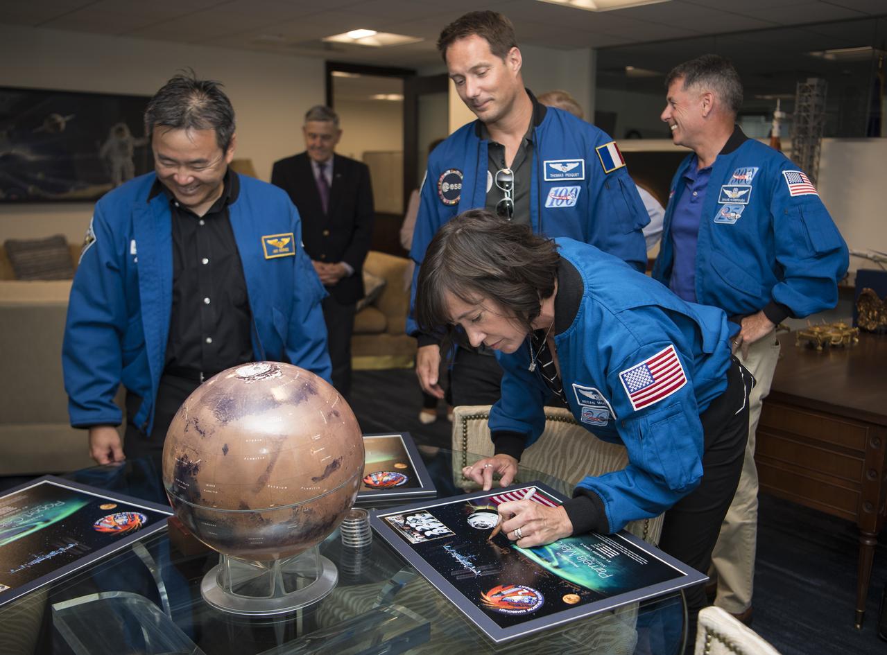 NASA’s SpaceX Crew-2 astronaut Megan McArthur signs a montage for NASA Deputy Administrator Pam Melroy while fellow Crew-2 members look on, Monday, June 6, 2022, at the Mary W. Jackson NASA Headquarters Building in Washington DC. Photo Credit: (NASA/Aubrey Gemignani)