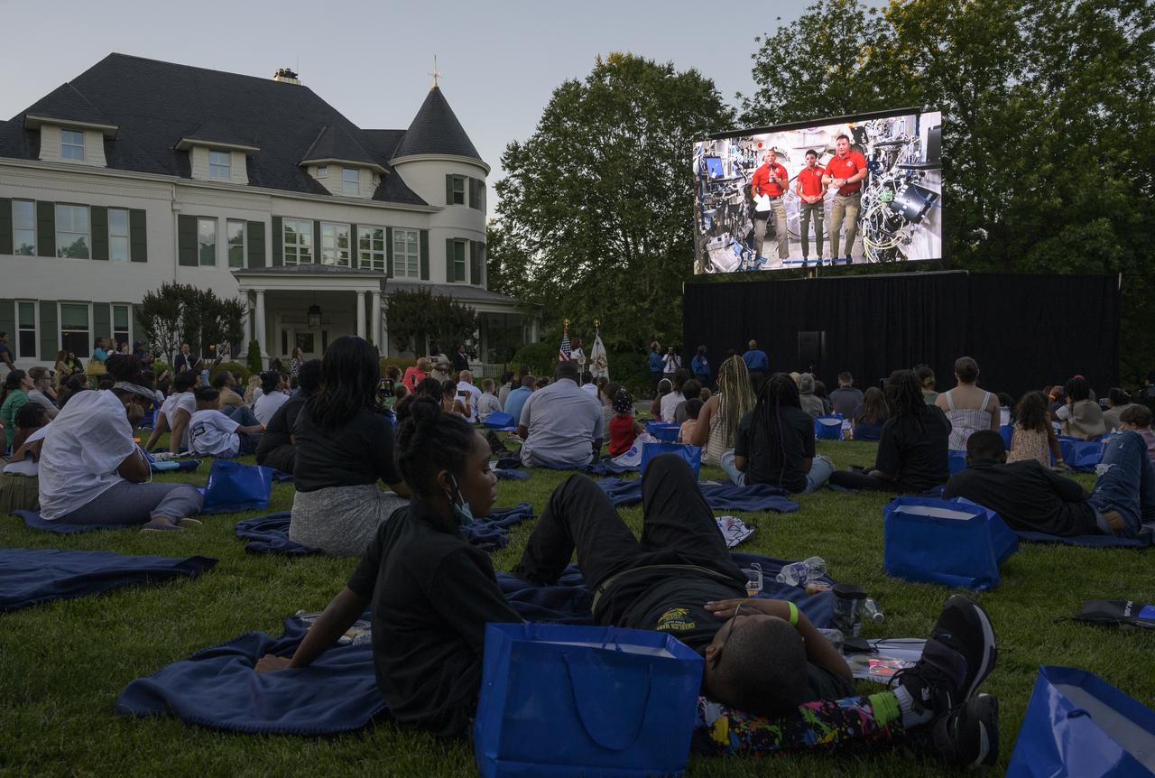 NASA astronauts Bob Hines, left, Jessica Watkins, and Kjell Lindgren, give remarks from the International Space Station prior to the screening of the movie Lightyear on the grounds of the Vice President's residence at the Naval Observatory, Friday, June 17, 2022, in Washington. The Vice President and Second Gentleman hosted an evening of NASA STEM activities at the Naval Observatory for military families and local STEM students and their families, including a special screening of Disney Pixar’s Lightyear. Photo Credit: (NASA/Bill Ingalls)