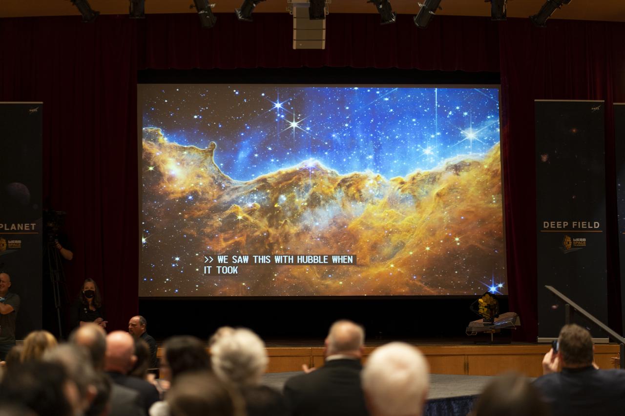 The image captured by NASA’s James Webb Space Telescope of the star-forming region called NGC 3324 in the Carina Nebula is seen on a screen as members of the media and guests watch the broadcast releasing the first full-color images from NASA’s James Webb Space Telescope, Tuesday, July 12, 2022, at NASA’s Goddard Space Flight Center in Greenbelt, Md.  The first full-color images and spectroscopic data from the James Webb Space Telescope, a partnership with ESA (European Space Agency) and the Canadian Space Agency (CSA), are a demonstration of the power of Webb as the telescope begins its science mission to unfold the infrared universe. Photo Credit: (NASA/Taylor Mickal)