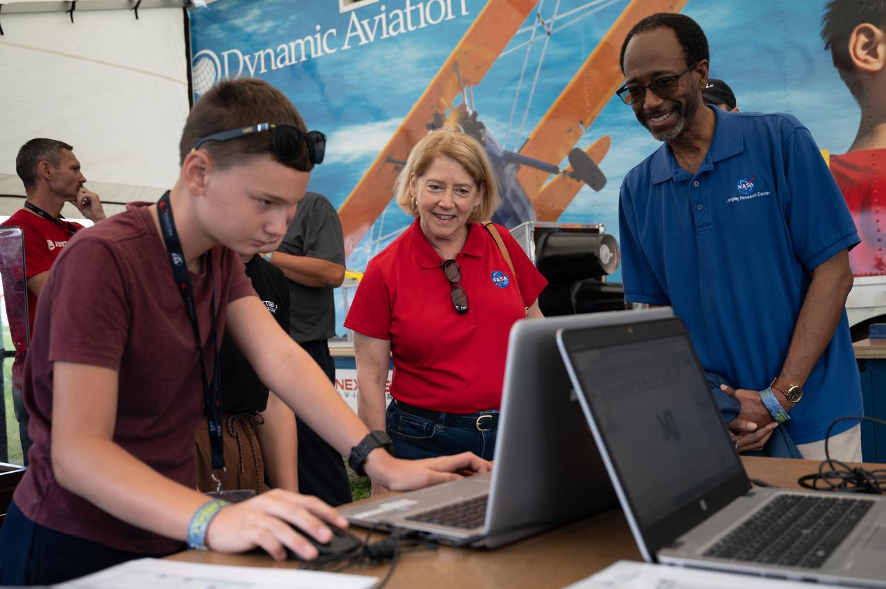 Silas Webb explains his CAD aircraft design to Deputy Administrator Pam Melroy and Langley Director Clayton Turner on Thursday, July 28, 2022, at the NEXTGEN Aviators exhibit at AirVenture Oshkosh.