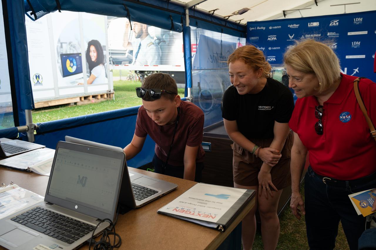Deputy Administrator Pam Melroy tours the NEXTGEN Aviators exhibit on Thursday, July 28, 2022, at EAA AirVenture. Here Silas Webb explains his CAD aircraft design with the help of Kala Dougan.