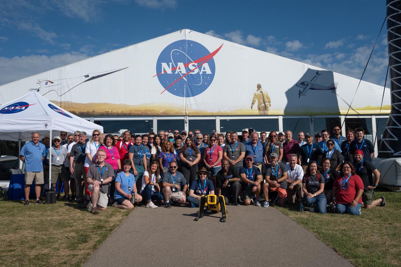 NASA staff pose for a group picture in front of the NASA's exhibit pavilion on Wednesday, July 27, 2022, at the EAA AirVenture at Oshkosh event.