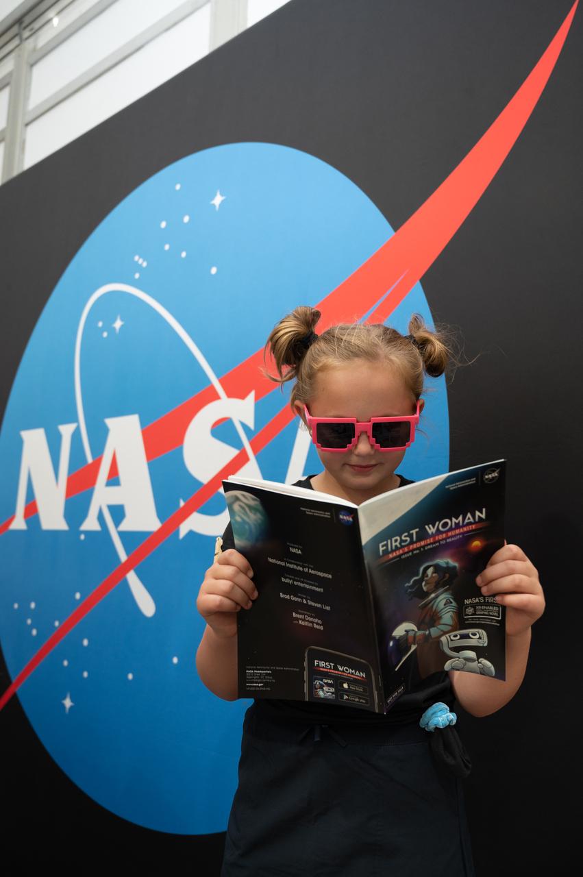 Ruby Flottum reads the first issue of NASA's "First Woman" graphic novel, entitled "Dream to Reality," on Monday, July 25, 2022 at AirVenture at Oshkosh.
