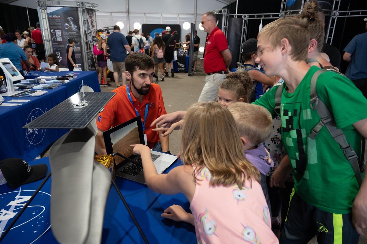 JPL Robotics Technologist Ben Morrell introduces the Mars Ingenuity Helicopter to a group of visitors on Saturday, July 30, 2022, in the NASA pavilion at AirVenture Oshkosh.