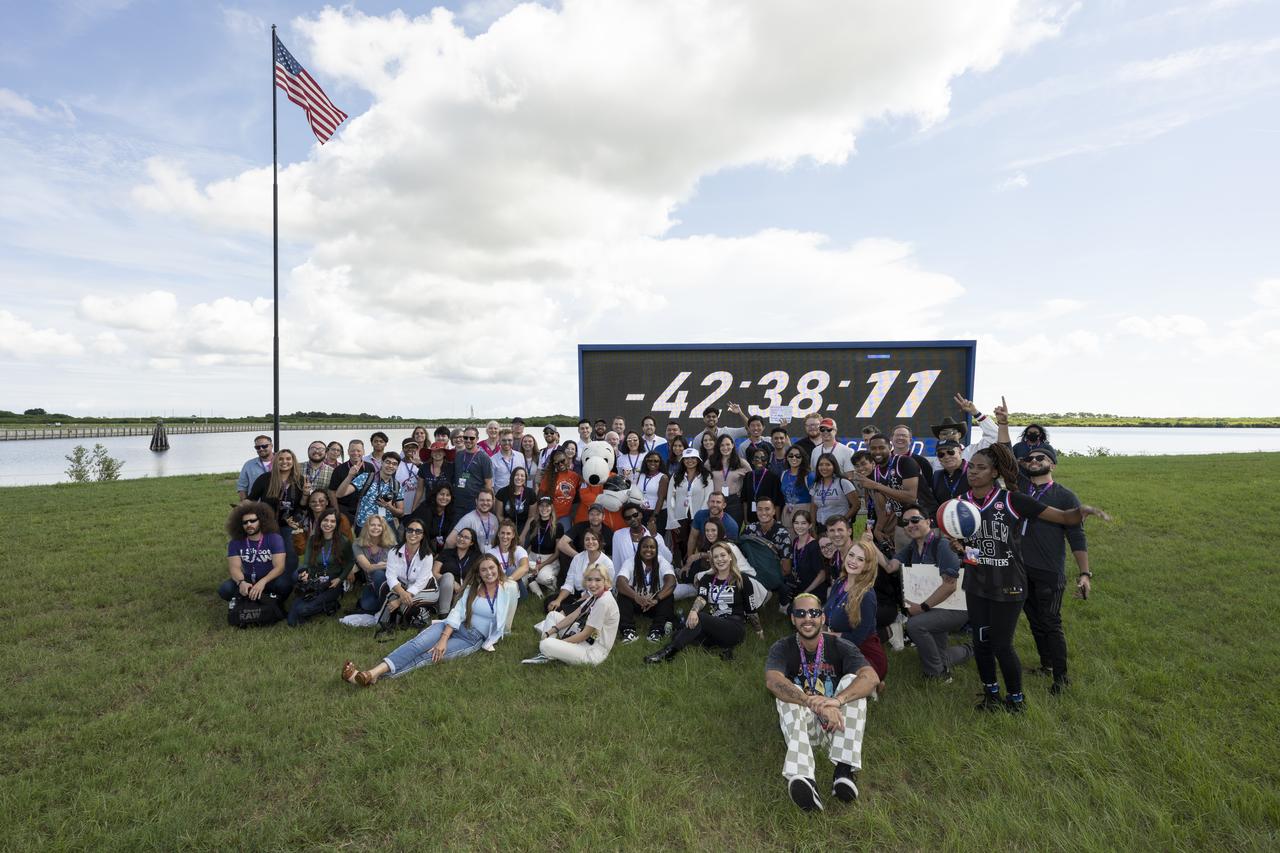 NASA Social attendees pose for a picture with Snoopy at the Press Site countdown clock, Saturday, Aug. 27, 2022, at NASA’s Kennedy Space Center in Florida. NASA’s Artemis I flight test is the first integrated flight test of the agency’s deep space exploration systems: the Orion spacecraft, Space Launch System (SLS) rocket, and ground systems. Launch of the uncrewed flight test is targeted for no earlier than Aug. 29 at 8:33 a.m. ET. Photo Credit: (NASA/Keegan Barber)