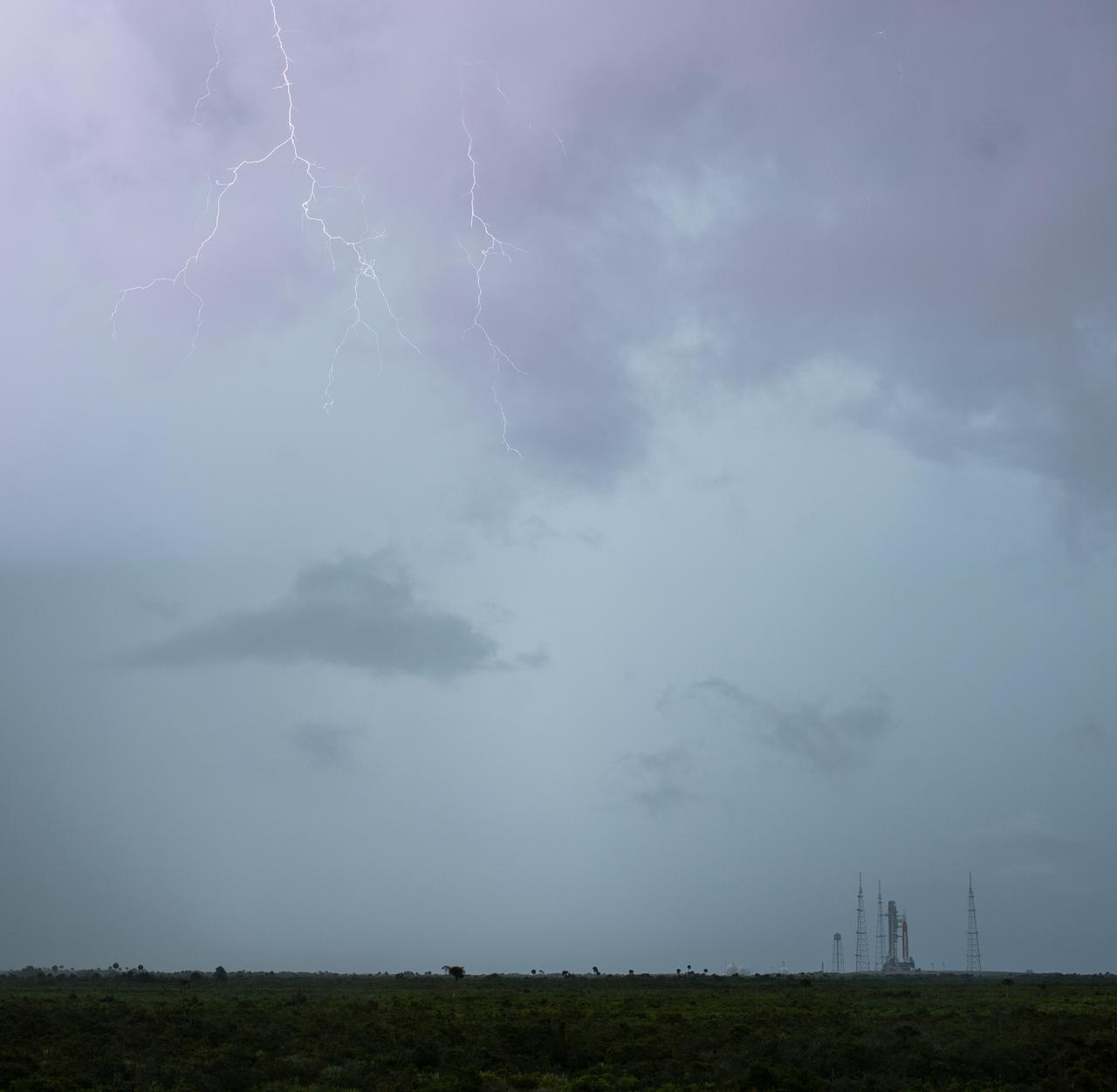 Lightning is seen near Launch Pad 39B as weather moves through the area as preparations for launch of NASA’s Space Launch System rocket and Orion spacecraft continue, Saturday, Aug. 27, 2022, at NASA’s Kennedy Space Center in Florida. NASA’s Artemis I flight test is the first integrated test of the agency’s deep space exploration systems: the Orion spacecraft, SLS rocket, and supporting ground systems. Launch of the uncrewed flight test is targeted for no earlier than Aug. 29 at 8:33 a.m. ET. Photo Credit: (NASA/Joel Kowsky)