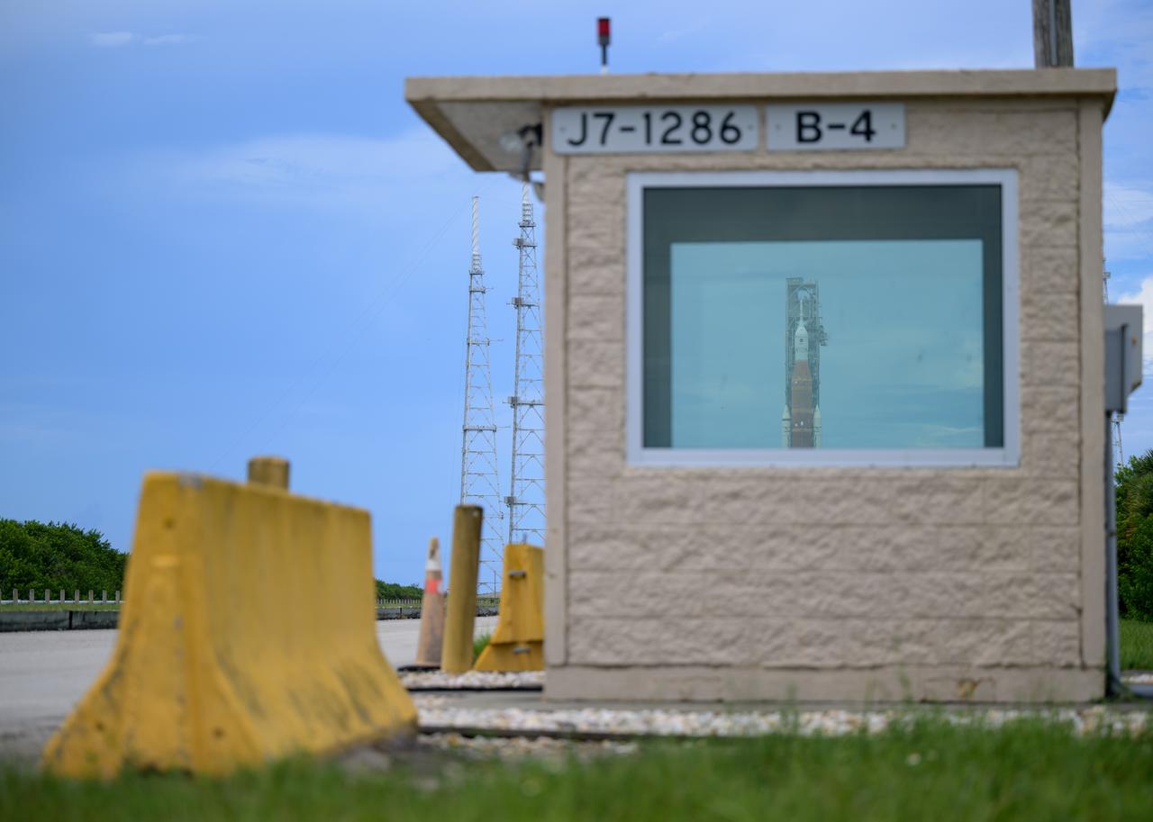 NASA’s Space Launch System (SLS) rocket with the Orion spacecraft aboard is seen through the window of a guard post at Launch Pad 39B as preparations for launch continue, Sunday, Aug. 28, 2022, at NASA’s Kennedy Space Center in Florida. NASA’s Artemis I flight test is the first integrated test of the agency’s deep space exploration systems: the Orion spacecraft, SLS rocket, and supporting ground systems. Launch of the uncrewed flight test is targeted for no earlier than Aug. 29 at 8:33 a.m. ET. Photo Credit: (NASA/Bill Ingalls)