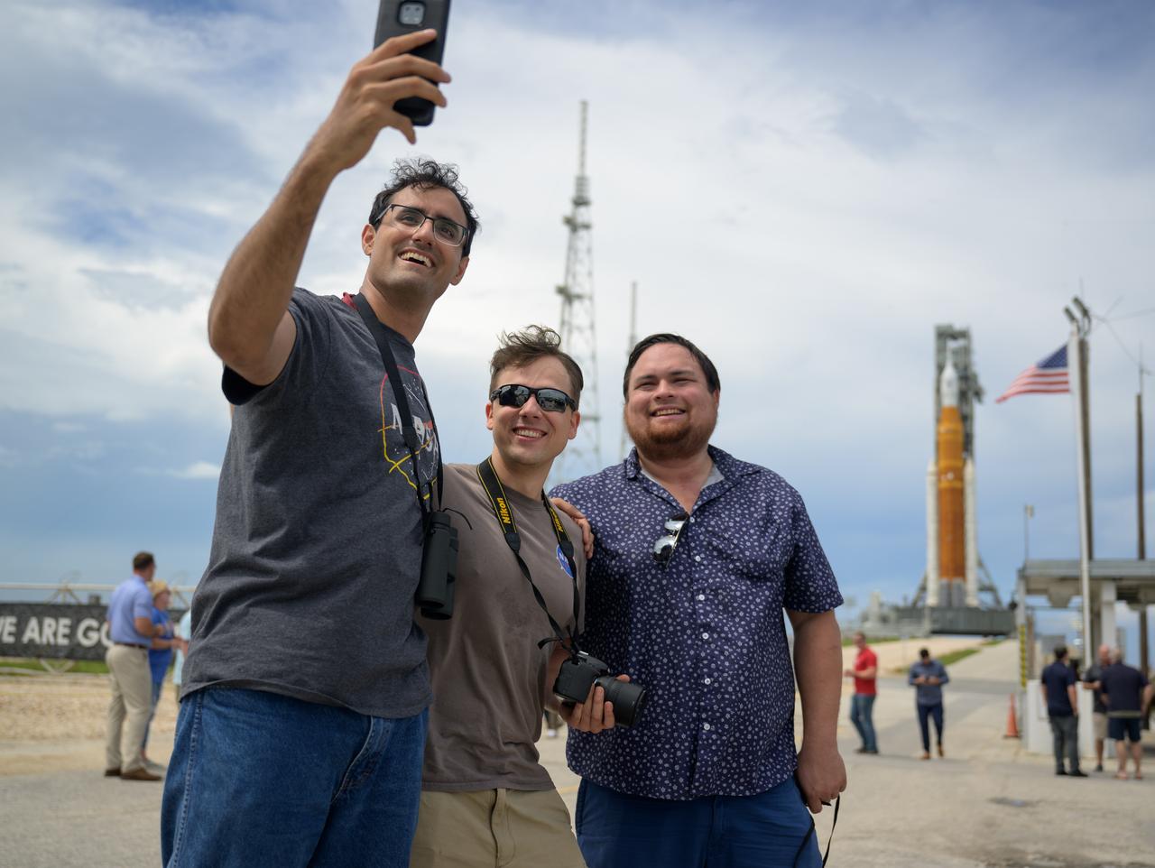 People stop outside the Launch Pad 39B gate to photograph themselves with NASA’s Space Launch System (SLS) rocket with the Orion spacecraft aboard as preparations for launch continue, Sunday, Aug. 28, 2022, at NASA’s Kennedy Space Center in Florida. NASA’s Artemis I flight test is the first integrated test of the agency’s deep space exploration systems: the Orion spacecraft, SLS rocket, and supporting ground systems. Launch of the uncrewed flight test is targeted for no earlier than Aug. 29 at 8:33 a.m. ET. Photo Credit: (NASA/Bill Ingalls)