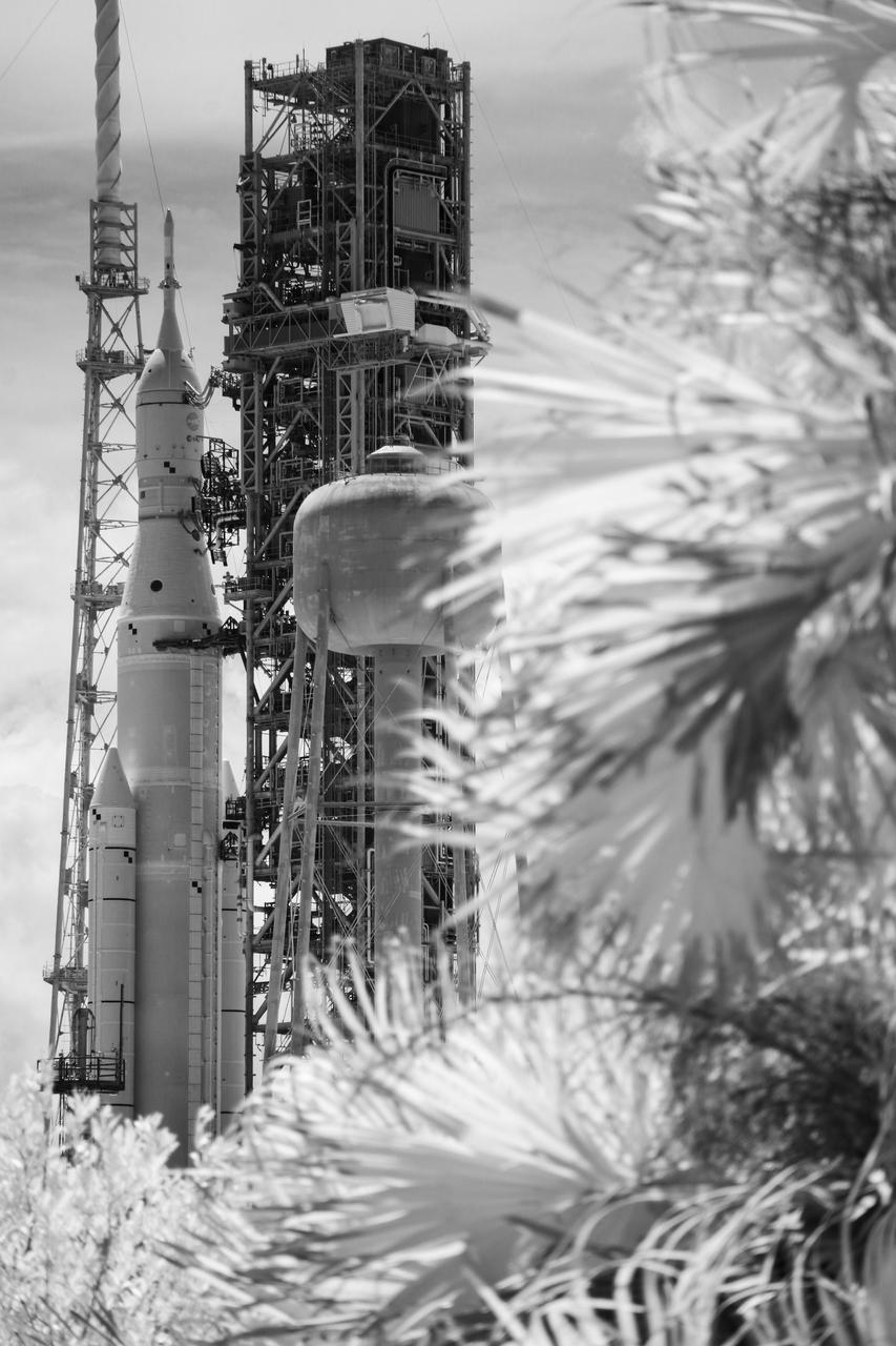 In this black and white infrared image, NASA’s Space Launch System (SLS) rocket with the Orion spacecraft aboard is seen atop the mobile launcher at Launch Pad 39B, Tuesday, Aug. 30, 2022, at NASA’s Kennedy Space Center in Florida. NASA’s Artemis I flight test is the first integrated test of the agency’s deep space exploration systems: the Orion spacecraft, SLS rocket, and supporting ground systems. Photo Credit: (NASA/Joel Kowsky)