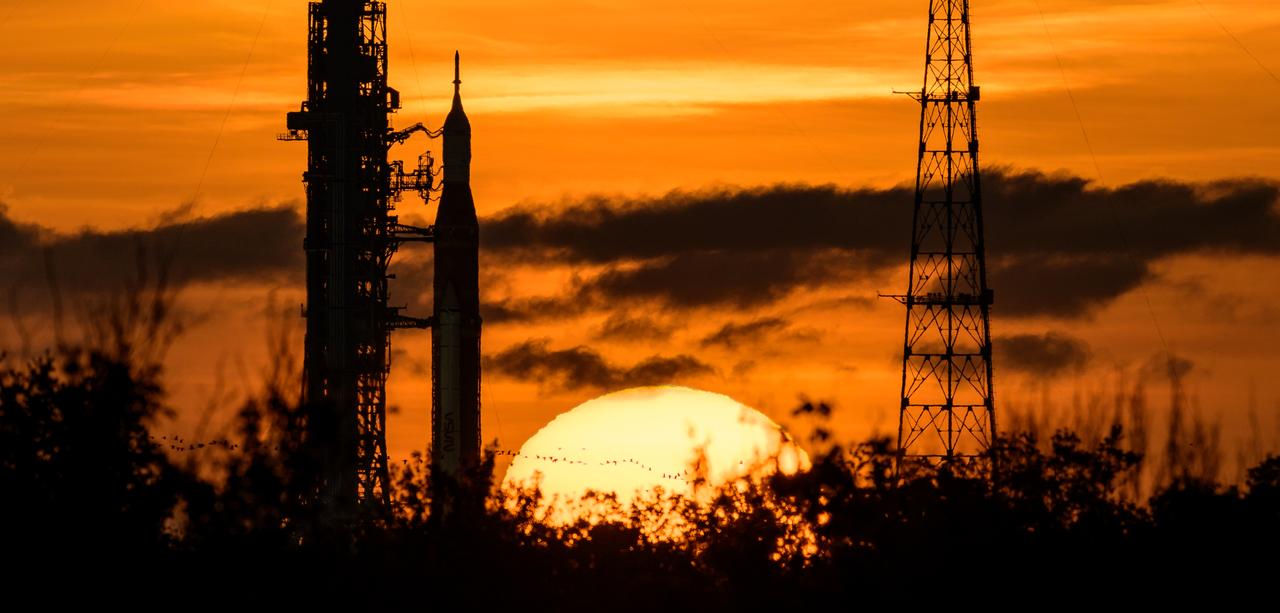 NASA’s Space Launch System (SLS) rocket with the Orion spacecraft aboard is seen during sunrise atop a mobile launcher at Launch Pad 39B as preparations for launch continue, Wednesday, Aug. 31, 2022, at NASA’s Kennedy Space Center in Florida. NASA’s Artemis I flight test is the first integrated test of the agency’s deep space exploration systems: the Orion spacecraft, SLS rocket, and supporting ground systems. Photo Credit: (NASA/Bill Ingalls)