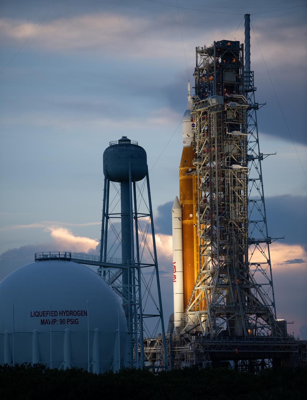NASA’s Space Launch System (SLS) rocket with the Orion spacecraft aboard is seen at sunset atop the mobile launcher at Launch Pad 39B as preparations for launch continue, Wednesday, Aug. 31, 2022, at NASA’s Kennedy Space Center in Florida. NASA’s Artemis I flight test is the first integrated test of the agency’s deep space exploration systems: the Orion spacecraft, SLS rocket, and supporting ground systems. Launch of the uncrewed flight test is targeted for Sept. 3 at 2:17 p.m. EDT. Photo Credit: (NASA/Joel Kowsky)