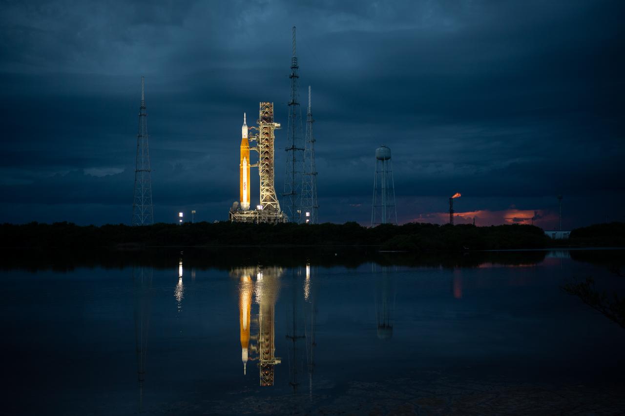 NASA’s Space Launch System (SLS) rocket with the Orion spacecraft aboard is seen at sunset atop the mobile launcher at Launch Pad 39B as preparations for launch continue, Wednesday, Aug. 31, 2022, at NASA’s Kennedy Space Center in Florida. NASA’s Artemis I flight test is the first integrated test of the agency’s deep space exploration systems: the Orion spacecraft, SLS rocket, and supporting ground systems. Launch of the uncrewed flight test is targeted for Sept. 3 at 2:17 p.m. EDT. Photo Credit: (NASA/Joel Kowsky)