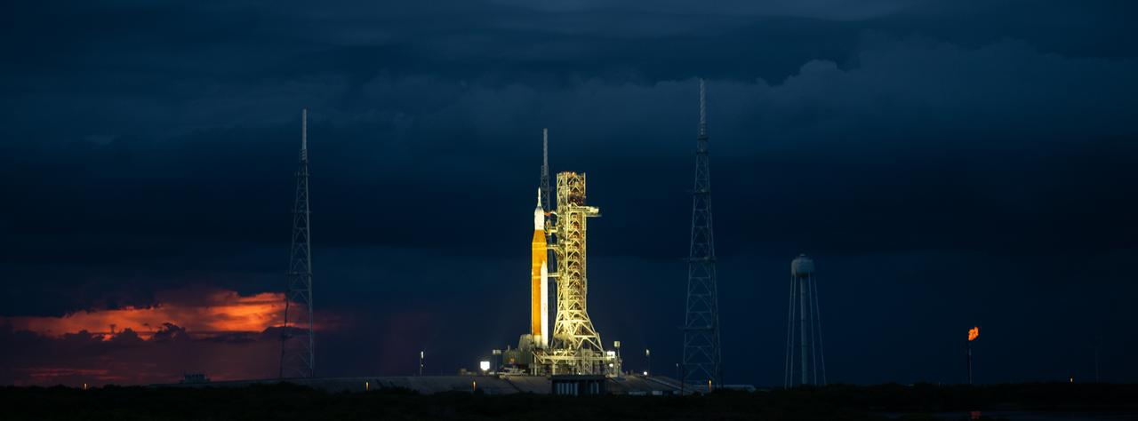 NASA’s Space Launch System (SLS) rocket with the Orion spacecraft aboard is seen at sunset atop the mobile launcher at Launch Pad 39B as preparations for launch continue, Wednesday, Aug. 31, 2022, at NASA’s Kennedy Space Center in Florida. NASA’s Artemis I flight test is the first integrated test of the agency’s deep space exploration systems: the Orion spacecraft, SLS rocket, and supporting ground systems. Launch of the uncrewed flight test is targeted for Sept. 3 at 2:17 p.m. EDT. Photo Credit: (NASA/Joel Kowsky)