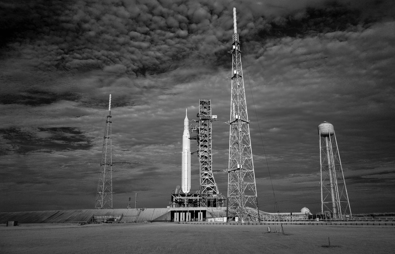 In this black and white infrared image, NASA’s Space Launch System (SLS) rocket with the Orion spacecraft aboard is seen atop a mobile launcher at Launch Pad 39B as preparations for launch continue, Friday, Sept. 2, 2022, at NASA’s Kennedy Space Center in Florida. NASA’s Artemis I flight test is the first integrated test of the agency’s deep space exploration systems: the Orion spacecraft, SLS rocket, and supporting ground systems. Launch of the uncrewed flight test is targeted for Sept. 3 at 2:17 p.m. EDT. Photo Credit: (NASA/Bill Ingalls)
