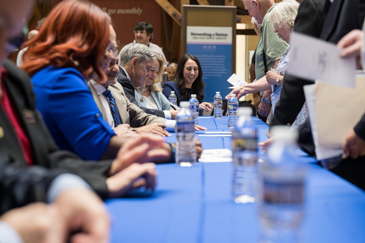Speakers at the first-day-of-issue event for the United States Postal Service’s new stamp celebrating NASA’s James Webb Space Telescope (JWST), autograph a piece of mail with the stamp on it, Thursday, Sept. 8, 2022, at the Smithsonian’s National Postal Museum in Washington. The stamp, which features an illustration of the observatory, honors Webb’s mission to explore the unknown in our universe – solving mysteries in our solar system, looking beyond to distant worlds around other stars, and probing the structures and origins of our universe and our place in it. Photo Credit: (NASA/Aubrey Gemignani)