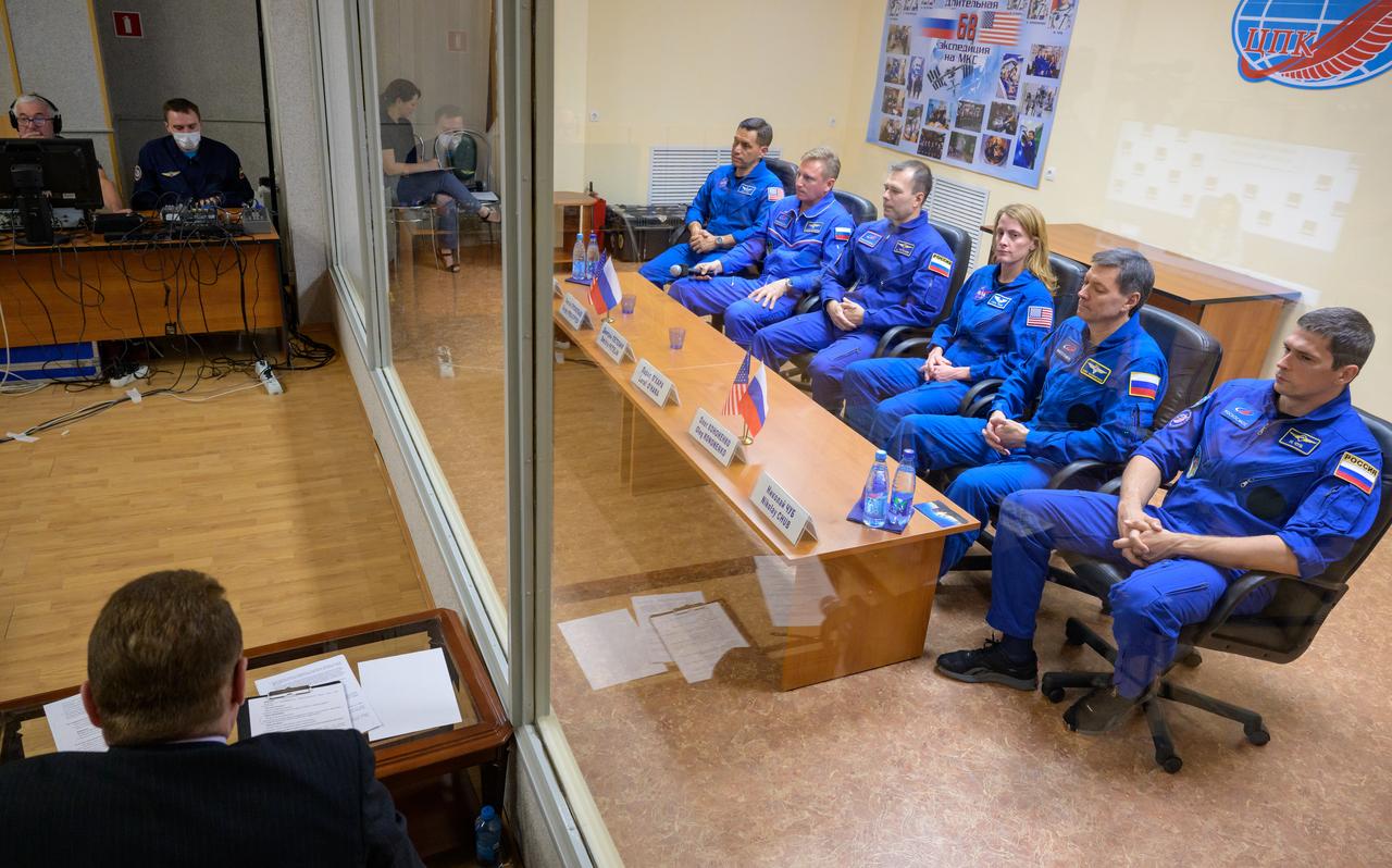 Expedition 68 astronaut Frank Rubio of NASA, left, cosmonauts Sergey Prokopyev and Dmitri Petelin of Roscosmos, along with Expedition 68 backup crewmembers Loral O'Hara of NASA, Oleg Kononenko and Nikolai Chub of Roscosmos, right, are seen in quarantine, behind glass, during a press conference, Tuesday, Sept. 20, 2022, at the Cosmonaut Hotel in Baikonur, Kazakhstan. Rubio, Prokoyev, and Petelin are scheduled to launch to the International Space Station aboard the Soyuz MS-22 spacecraft on Sept. 21. Photo Credit: (NASA/Bill Ingalls)