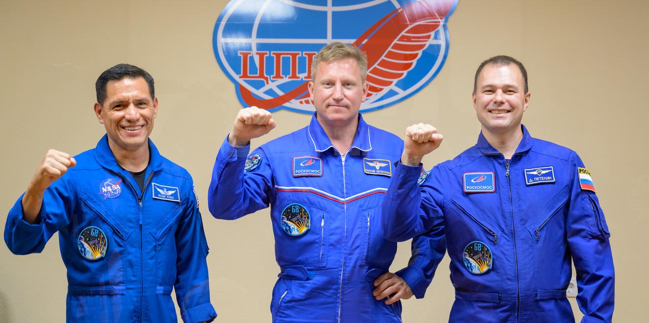 Expedition 68 astronaut Frank Rubio of NASA, left, and cosmonauts Sergey Prokopyev and Dmitri Petelin of Roscosmos, right, are seen in quarantine, behind glass, during a press conference, Tuesday, Sept. 20, 2022, at the Cosmonaut Hotel in Baikonur, Kazakhstan. The trio are scheduled to launch to the International Space Station aboard the Soyuz MS-22 spacecraft on Sept. 21. Photo Credit: (NASA/Bill Ingalls)