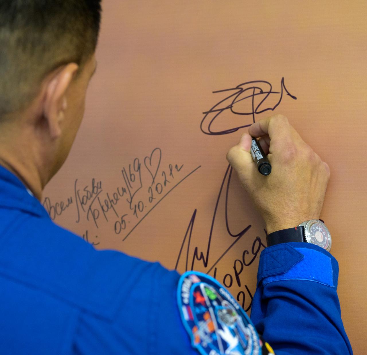Expedition 68 astronaut Frank Rubio of NASA signs a photo inside the Cosmonaut Hotel prior to departing for building 254 in order to suitup for launch on a Soyuz rocket with fellow crewmates Dmitri Petelin and Sergey Prokopyev of Roscosmos, Wednesday, Sept. 21, 2022, in Baikonur, Kazakhstan. Rubio, Prokopyev and Petelin launched on their Soyuz MS-22 spacecraft later in the day from the Baikonur Cosmodrome for a mission on the International Space Station. Photo Credit: (NASA/Bill Ingalls)