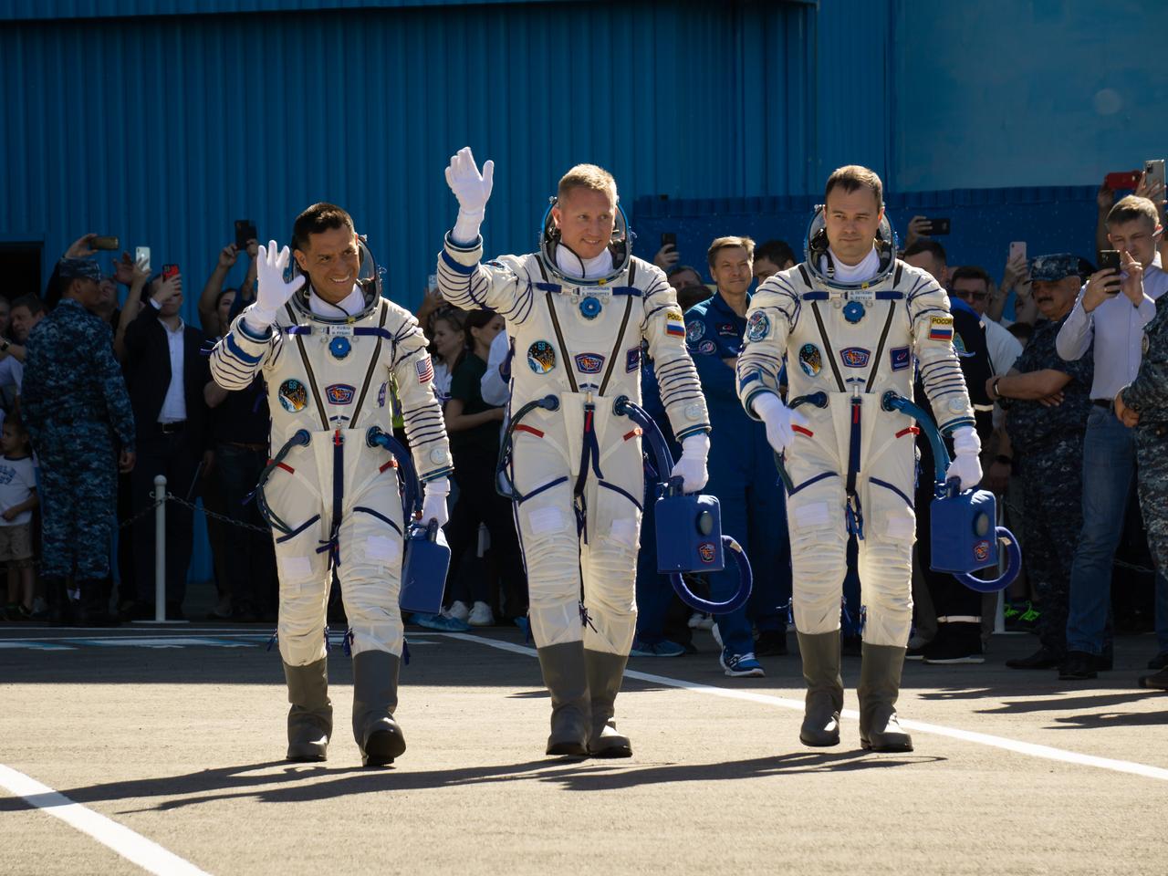 Expedition 68 astronaut Frank Rubio of NASA, left, and cosmonauts Sergey Prokopyev and Dmitri Petelin of Roscosmos, wave farewell as they depart building 254 for the launch pad and their Soyuz MS-22 spacecraft launch, Wednesday, Sept. 21, 2022, in Baikonur, Kazakhstan. Rubio, Prokopyev and Petelin launched onboard the Soyuz rocket from the Baikonur Cosmodrome for a mission on the International Space Station. Photo Credit: (NASA/Victor Zelentsov)