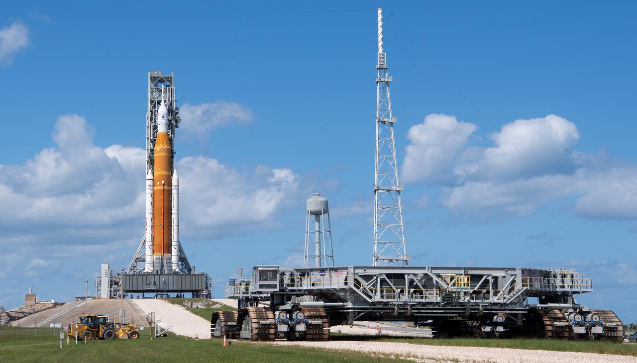 Crawler Transporter-2 (CT-2) is seen outside the gates at Launch Pad 39B as teams configure systems for rolling NASA’s Space Launch System (SLS) rocket and Orion spacecraft back to the Vehicle Assembly Building, Saturday, Sept. 24, 2022, at NASA’s Kennedy Space Center in Florida. NASA is foregoing a launch opportunity on Tues. Sept. 27 and continues to watch the weather forecast associated with Tropical Storm Ian. The NASA’s Artemis I flight test is the first integrated test of the agency’s deep space exploration systems: the Orion spacecraft, SLS rocket, and supporting ground systems.  Photo Credit: (NASA/Joel Kowsky)